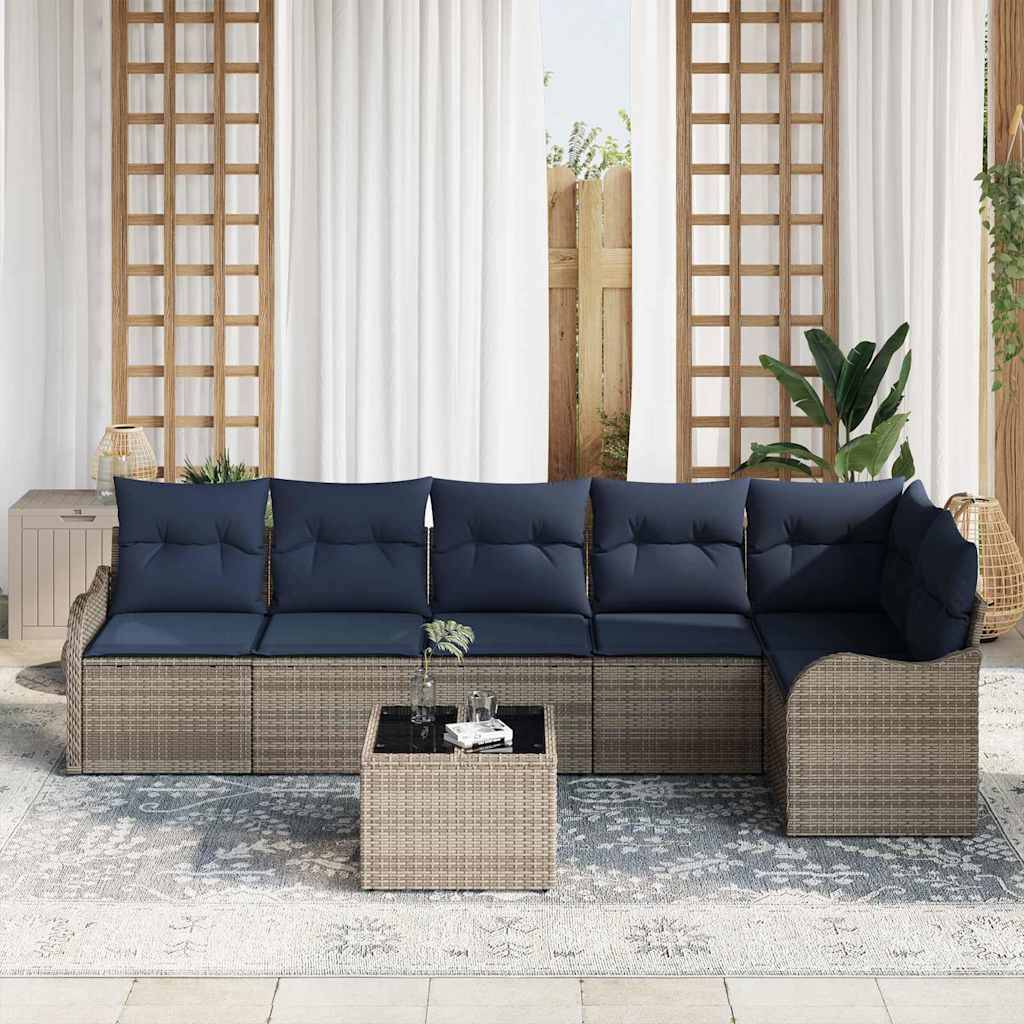 Outdoor-Sitzbereich auf der Terrasse mit einem Korbgeflecht-Sitzkissen, marineblauen Kissen, passendem Ottoman-Tisch und einem gemusterten Teppich vor weißen Vorhängen und hölzernen Spalieren.