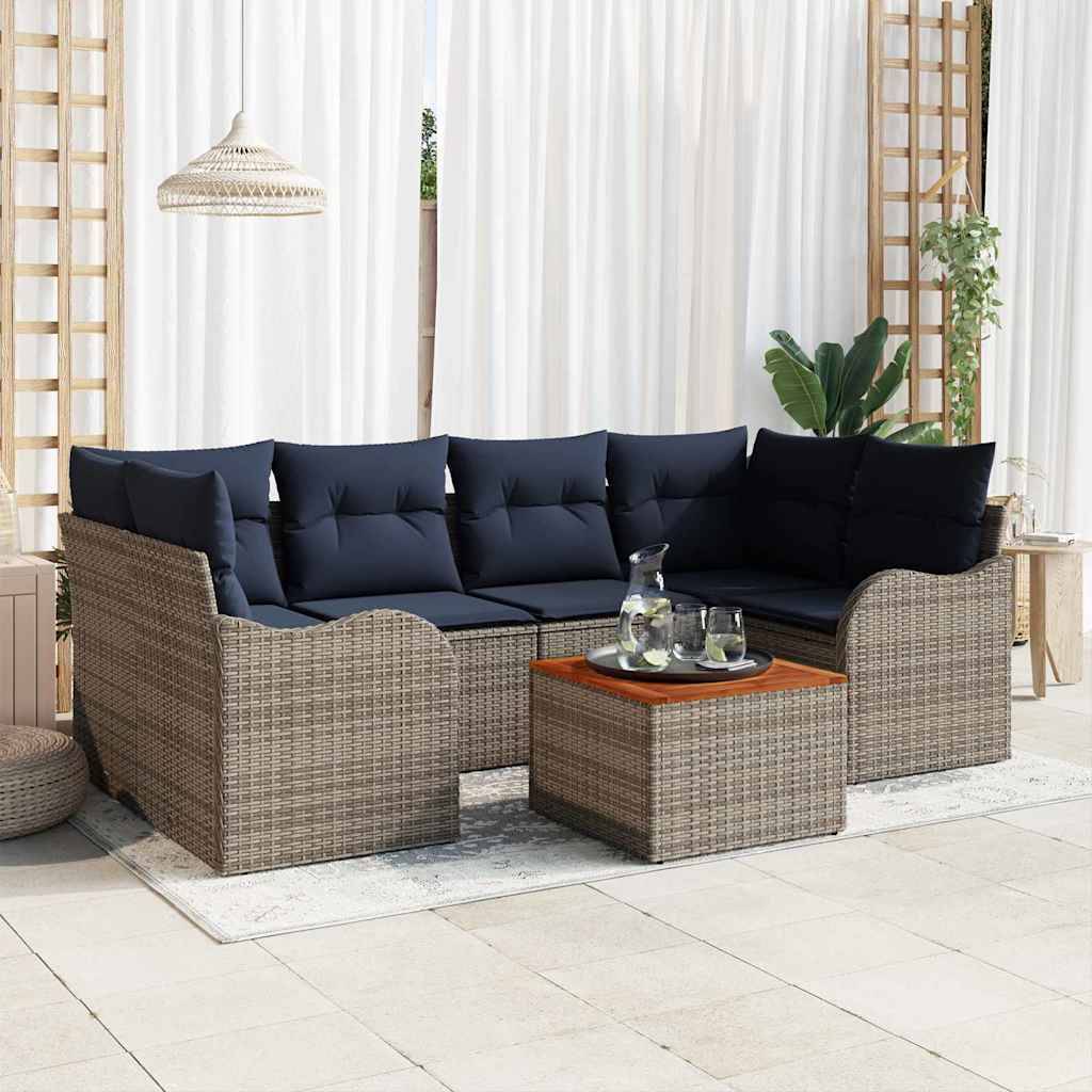 Outdoor-Rattansektionalsofa mit dunklen Kissen und passendem Couchtisch auf einer Terrasse vor durchsichtigen Vorhängen.