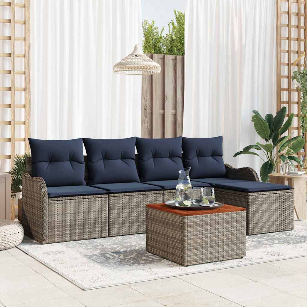 Outdoor-Sektionalsofa im Korbgeflecht-Stil mit marineblauen Kissen und passendem Couchtisch in einem hellen, terrassenähnlichen Raum mit Pflanzen und weißen Vorhängen.
