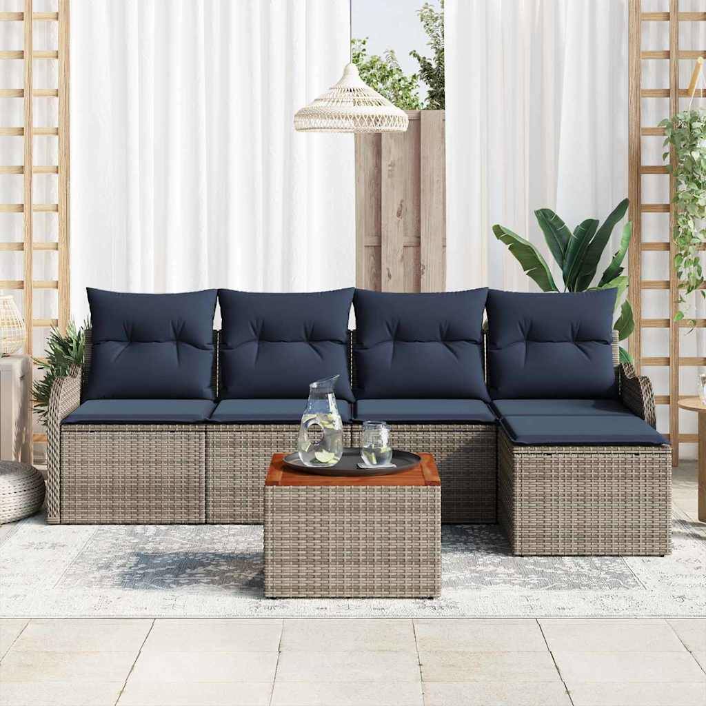 Outdoor-Rattanecksofa mit dunkelblauem Kissen und passendem Ottoman-Couchtisch in einer hellen Terrasseneinstellung.
