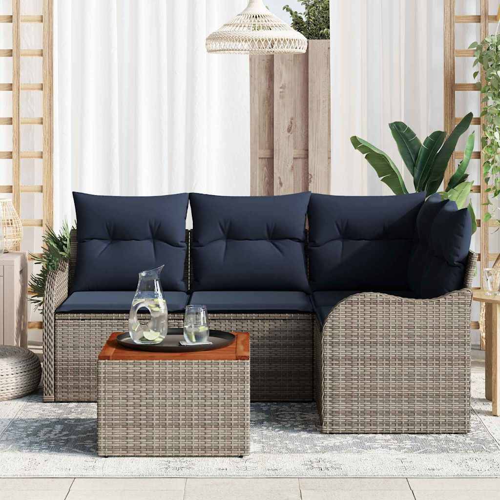 Outdoor-Rattansektionalsofa mit dunklen Kissen und passendem Couchtisch im Ottomane-Stil in einer Terrassenumgebung, mit Pflanzen und einer Hängeleuchte.