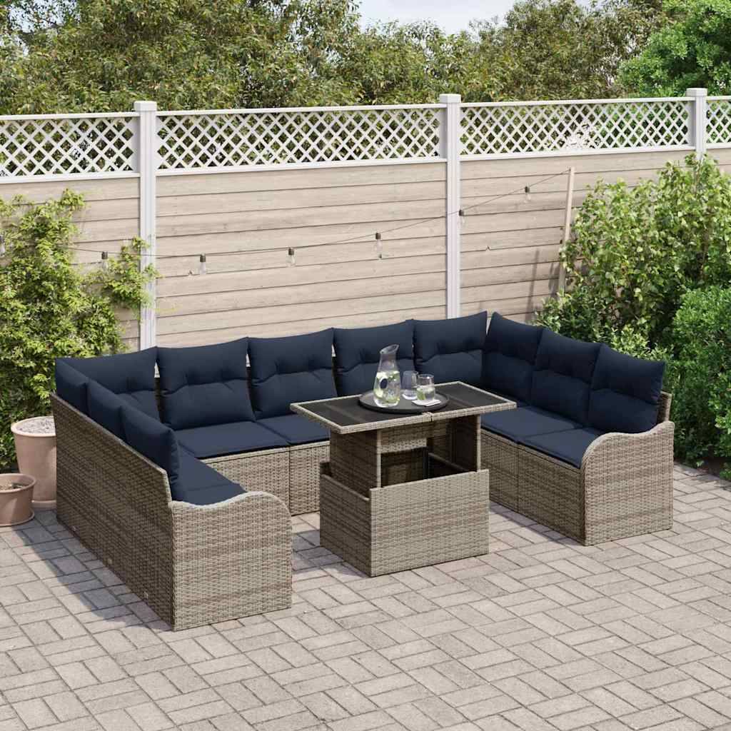 Outdoor-Terrasse mit einem L-förmigen Korbgeflecht-Ecksofa und Couchtisch auf einer gepflasterten Terrasse vor einer Gartenzaun-Kulisse.