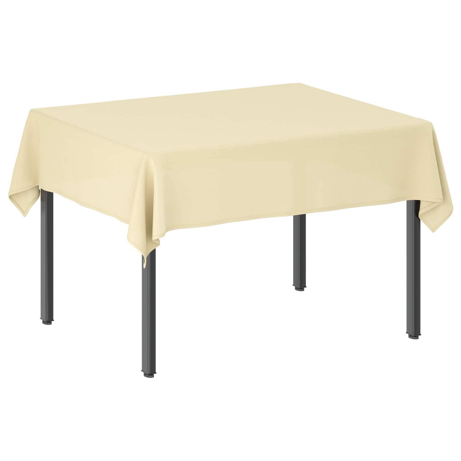 Ein quadratischer Tisch, der mit einer hellbeigen Tischdecke bedeckt ist, mit vier dunklen Beinen, die sich vor einem einfachen weißen Hintergrund abheben.