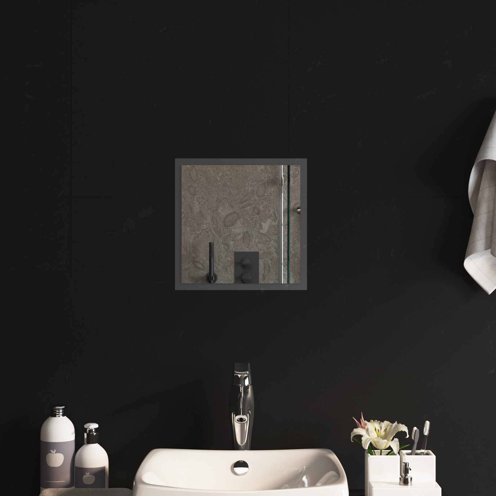 Modernes Badezimmer-Waschtisch mit schwarzen Wänden, quadratischem Spiegel, weißem Waschbecken, Chromarmatur, Seifenflaschen und kleiner Blumengesteck.