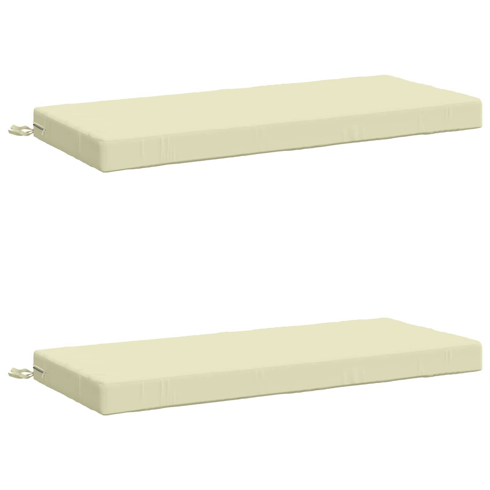 Zwei identische beige rechteckige Sitzkissen, die separat auf weißem Hintergrund gezeigt werden, jedes mit einer kleinen Schleife an einem Ende.