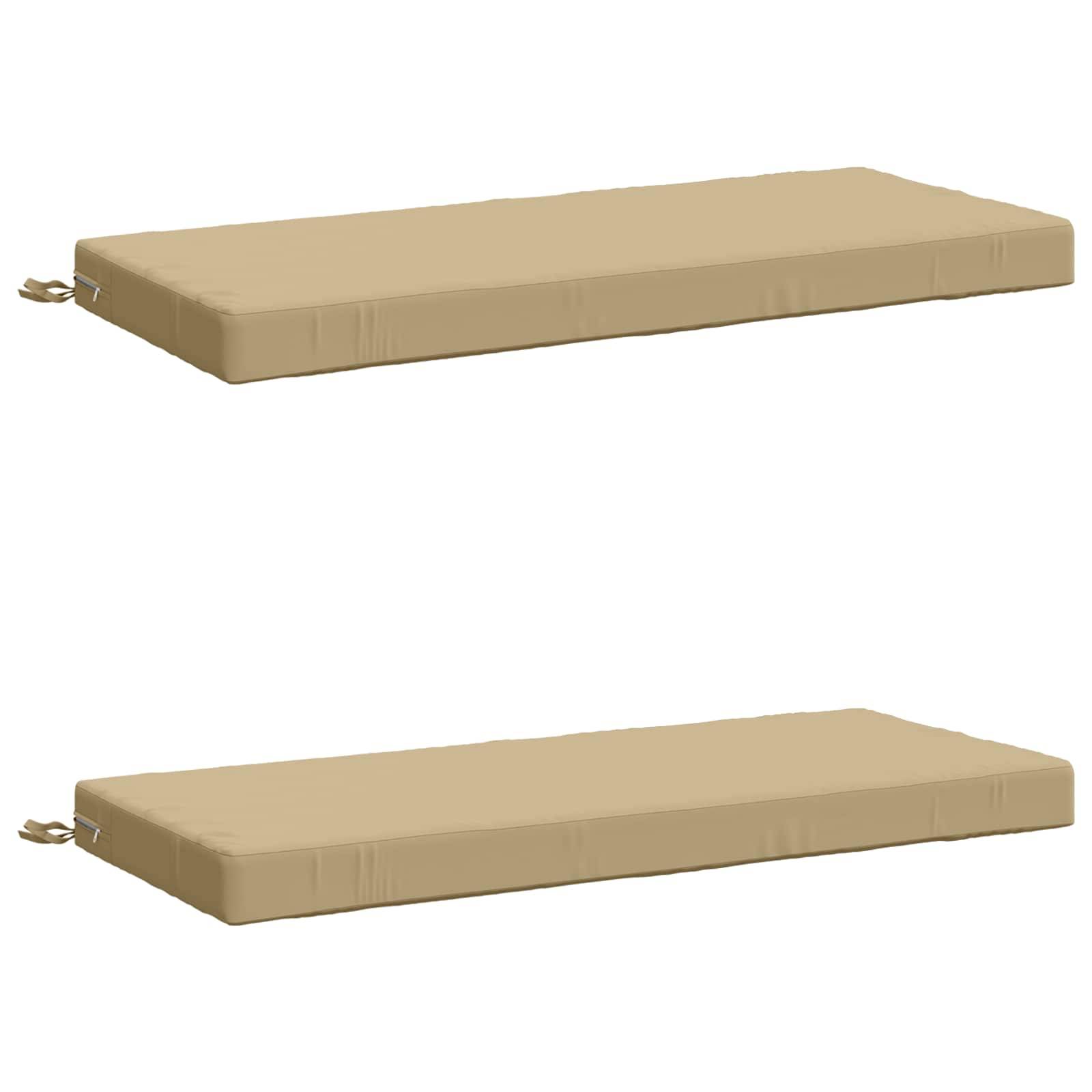 Zwei beige rechteckige Sitzkissen, separat auf weißem Hintergrund abgebildet, jeweils mit einem kleinen seitlichen Riemen oder Band.