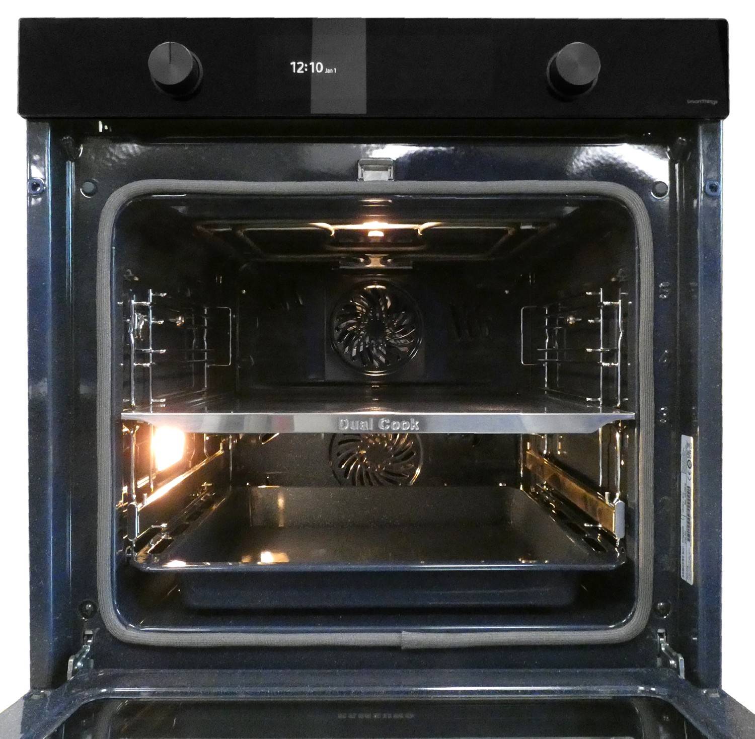 Elektrischer Backofen offen mit eingeschalteter Innenbeleuchtung und zwei Drahtgittern, die den leeren Garraum und die Bedienknöpfe oben zeigen.