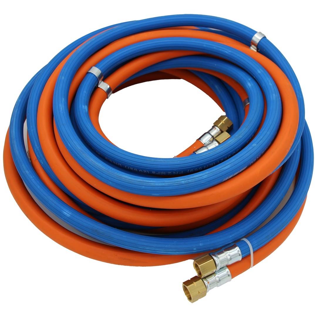 Aufgerollter blau und orange gefärbter Industrieschlauch mit Messingverbindungen auf weißem Hintergrund.