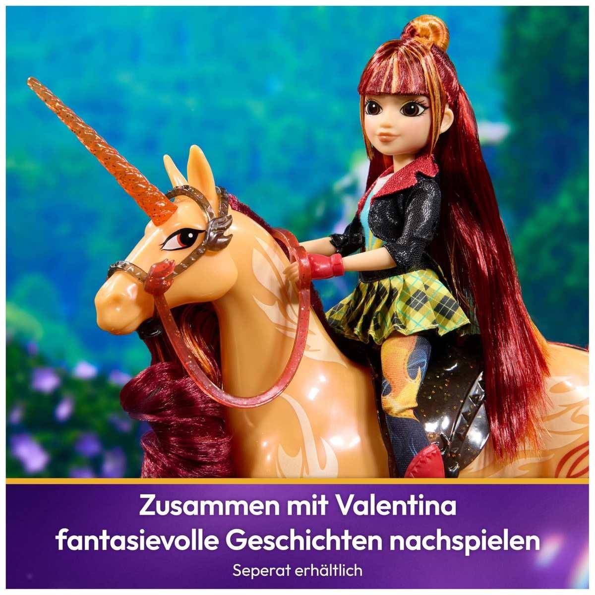 Mädchen mit langen roten Haaren sitzt auf einem Einhorn-Spielzeug; Der deutsche Text lautet 