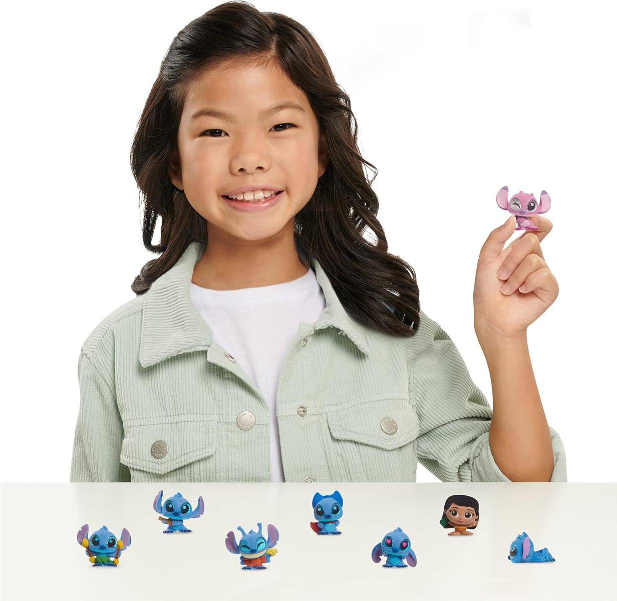 Lächelndes Mädchen hält ein kleines Stitch-Spielzeug, mit mehreren Stitch-Charakterfiguren, die entlang des Bodens angezeigt werden.