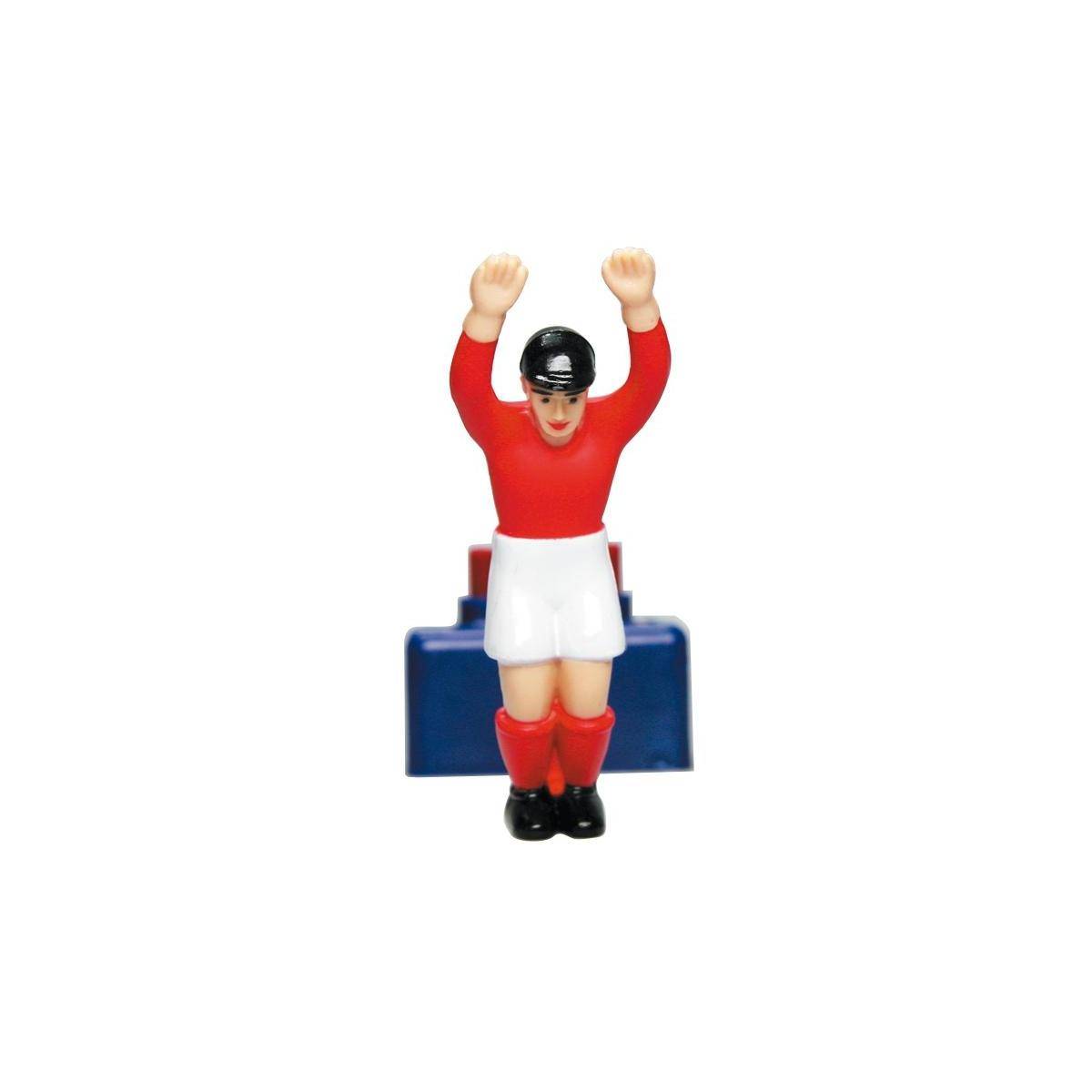 Miniatur-Fußballspieler-Figur in rotem Trikot und weißen Shorts mit beiden erhobenen Armen, stehend vor einer blauen Bank.
