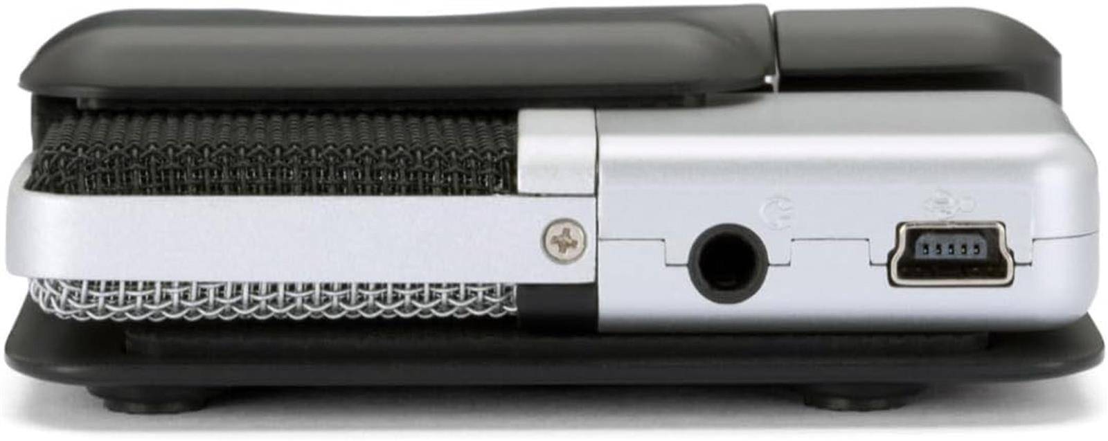 Seitenansicht eines tragbaren elektronischen Geräts mit schwarzer Ober- und Unterseite, silbernem Gehäuse, zentralem rundem Anschluss und einem kleinen Stecker auf der rechten Seite.