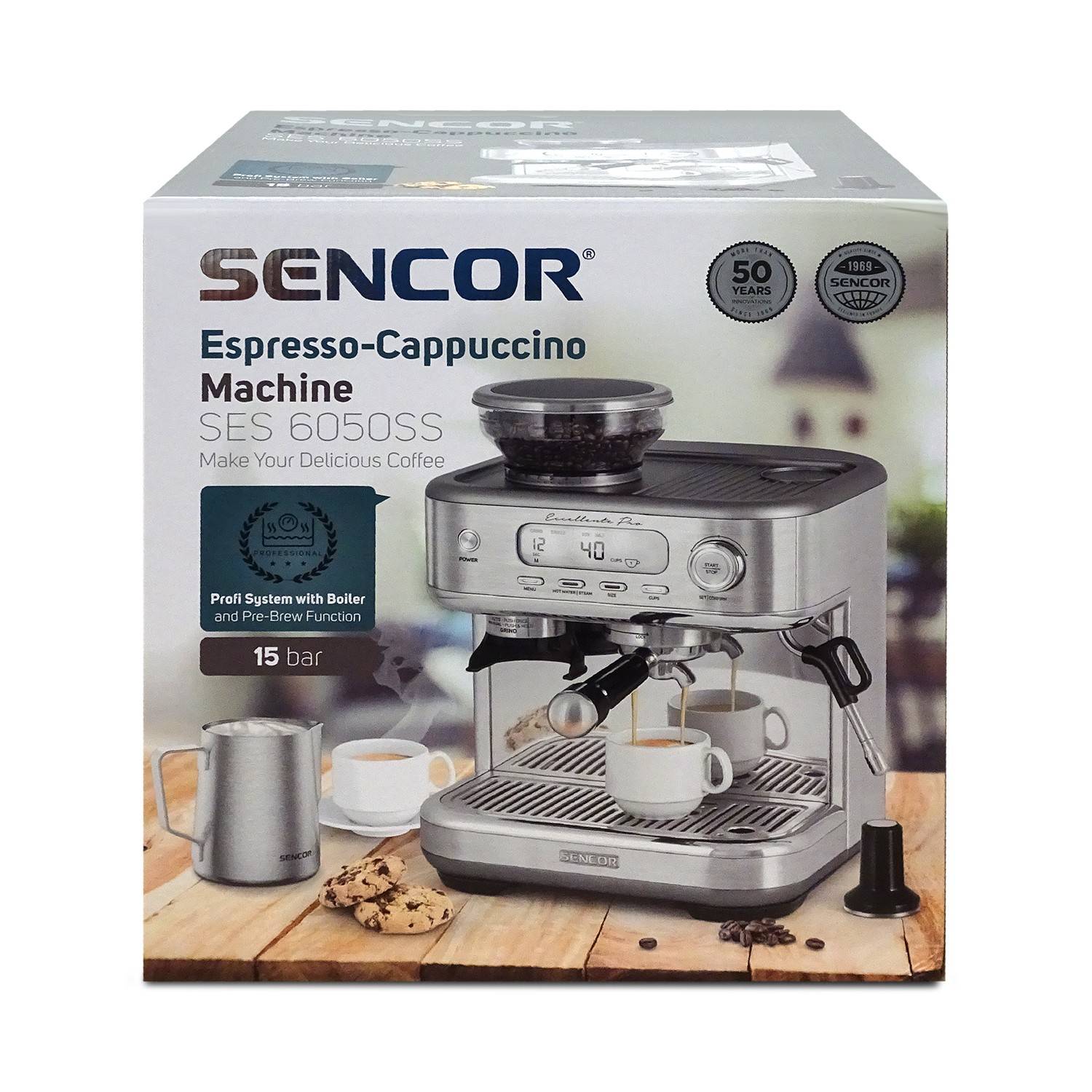Sencor SES 6050SS Espresso-Cappuccino-Maschinen-Karton, zeigt eine Edelstahl-Kaffeemaschine mit Tassen, Milchaufschäum-Kanne und 15-bar-Druckfunktion.