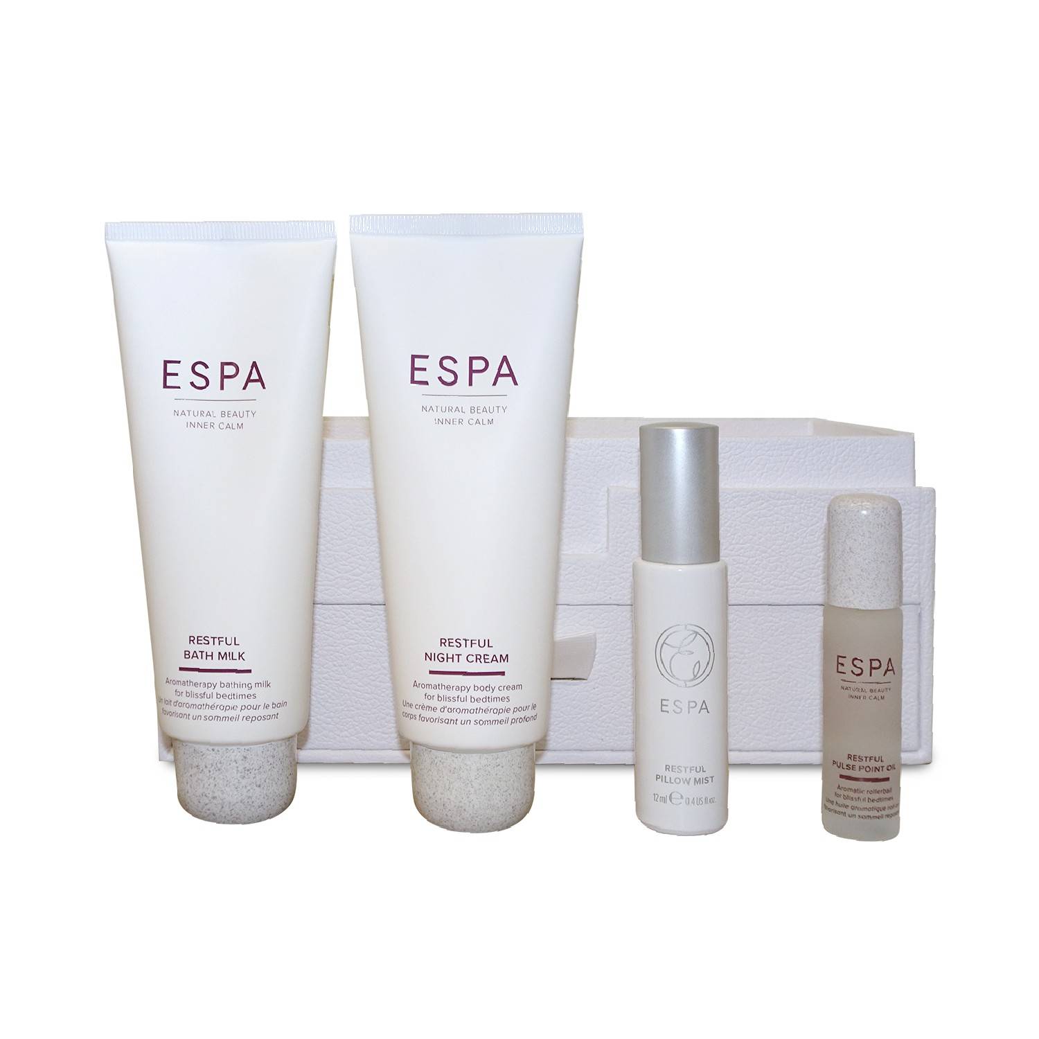 Vier ESPA-Hautpflegeprodukte, die vor gefalteten weißen Handtüchern angezeigt werden, darunter Restful Bath Milk, Restful Night Cream, eine Sprühflasche und eine kleine Lotion-Flasche.