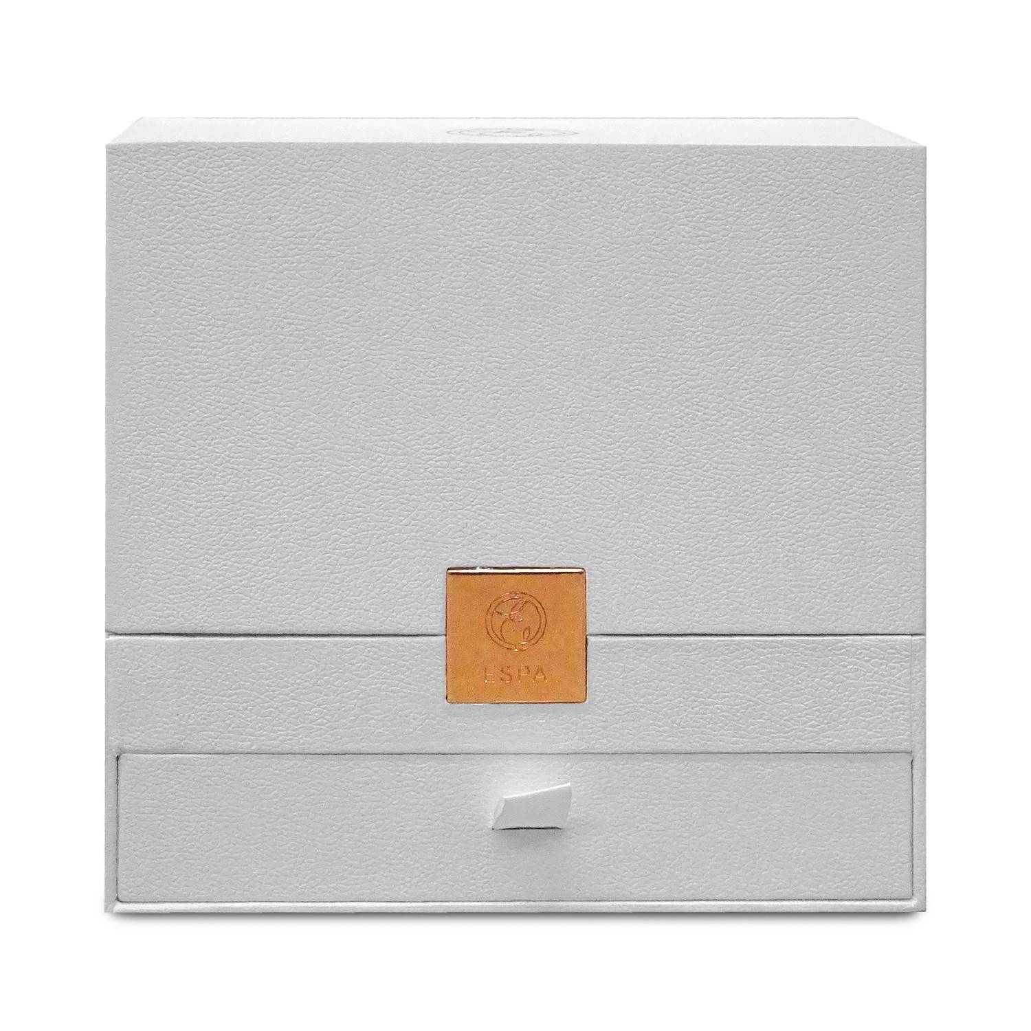Graue strukturierte Geschenkbox mit einer quadratischen goldenen Logo-Plakette und einer kleinen Zuglasche auf der Vorderseite