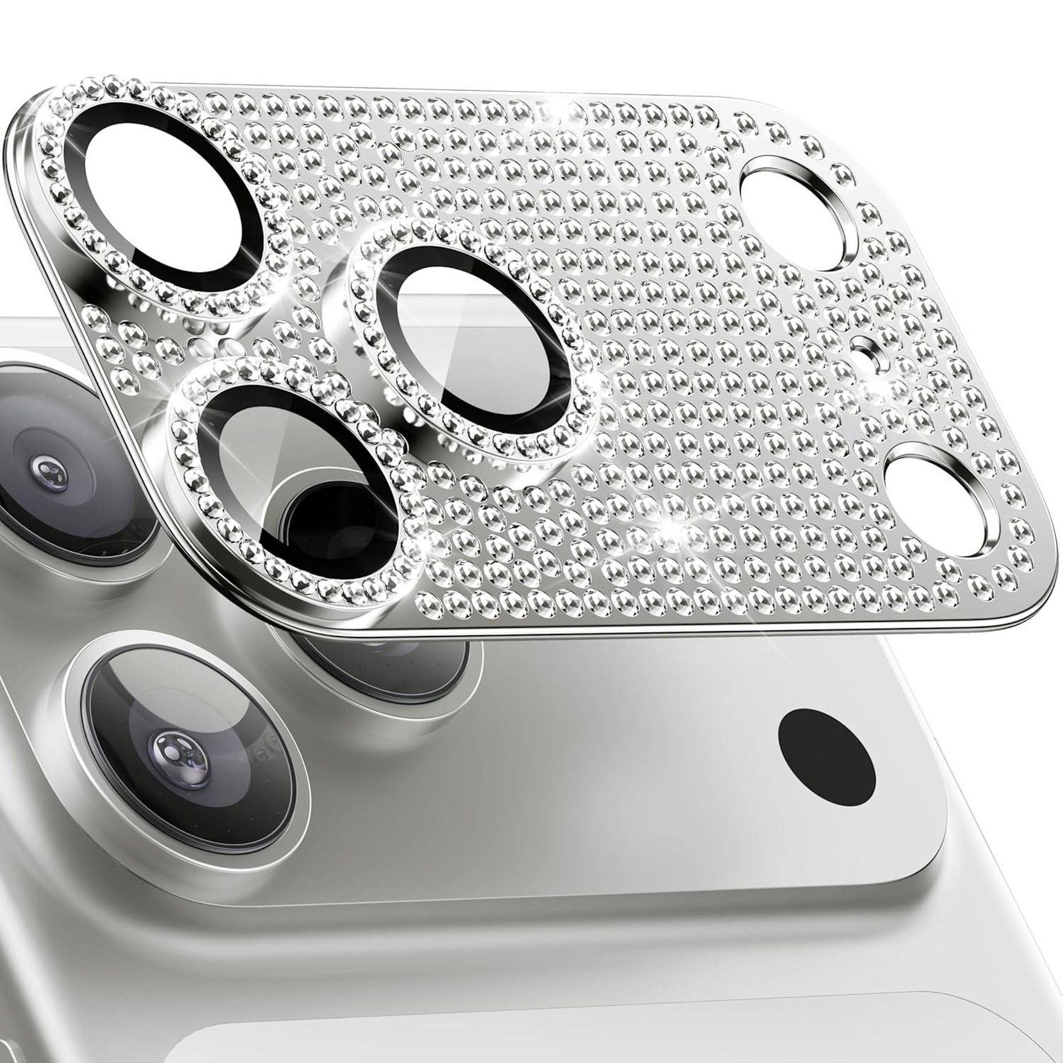 Nahaufnahme eines silbernen Smartphones mit einer glitzernden Strass-Kameraobjektiv-Schutzfolie, die drei rückseitige Kameraausschnitte abdeckt.