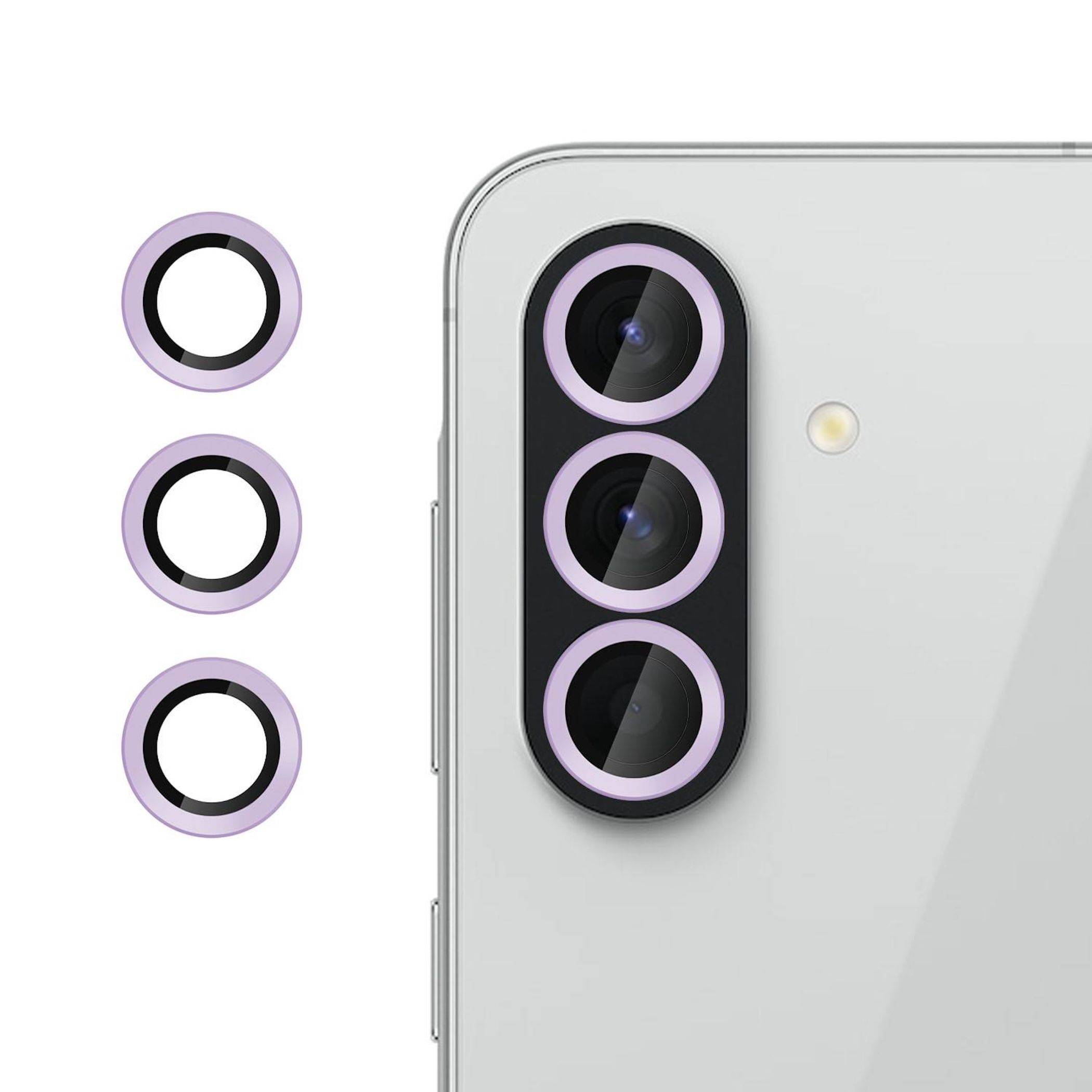 Nahaufnahme der Rückseite eines silbernen Smartphones, die ein dreifaches hinteres Kameramodul mit drei violetten Linsenringen und einem LED-Blitz zeigt.