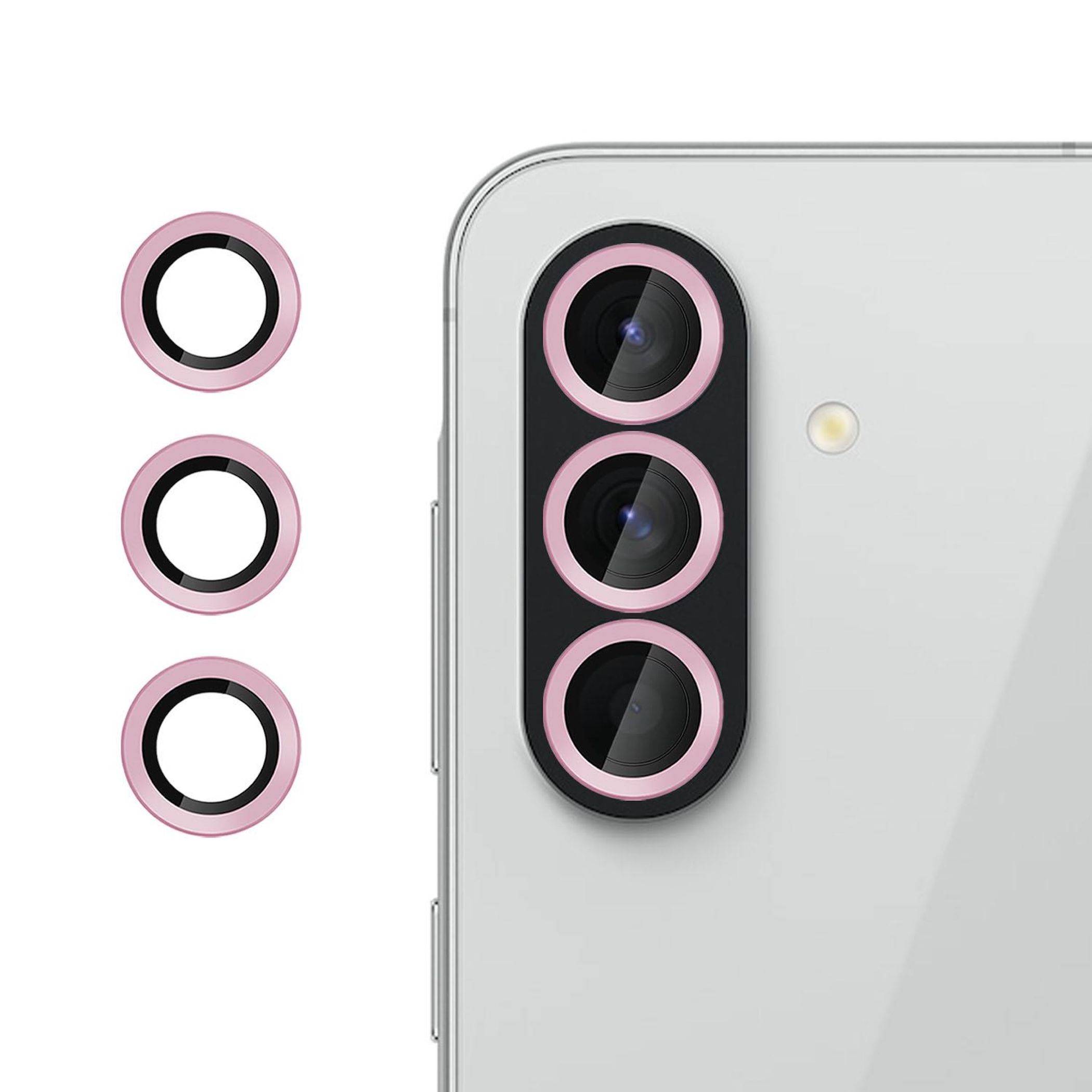 Rückseite eines Smartphone-Kameramoduls mit drei rosa Linsenringen, dargestellt neben drei separaten passenden Ringzubehörteilen.