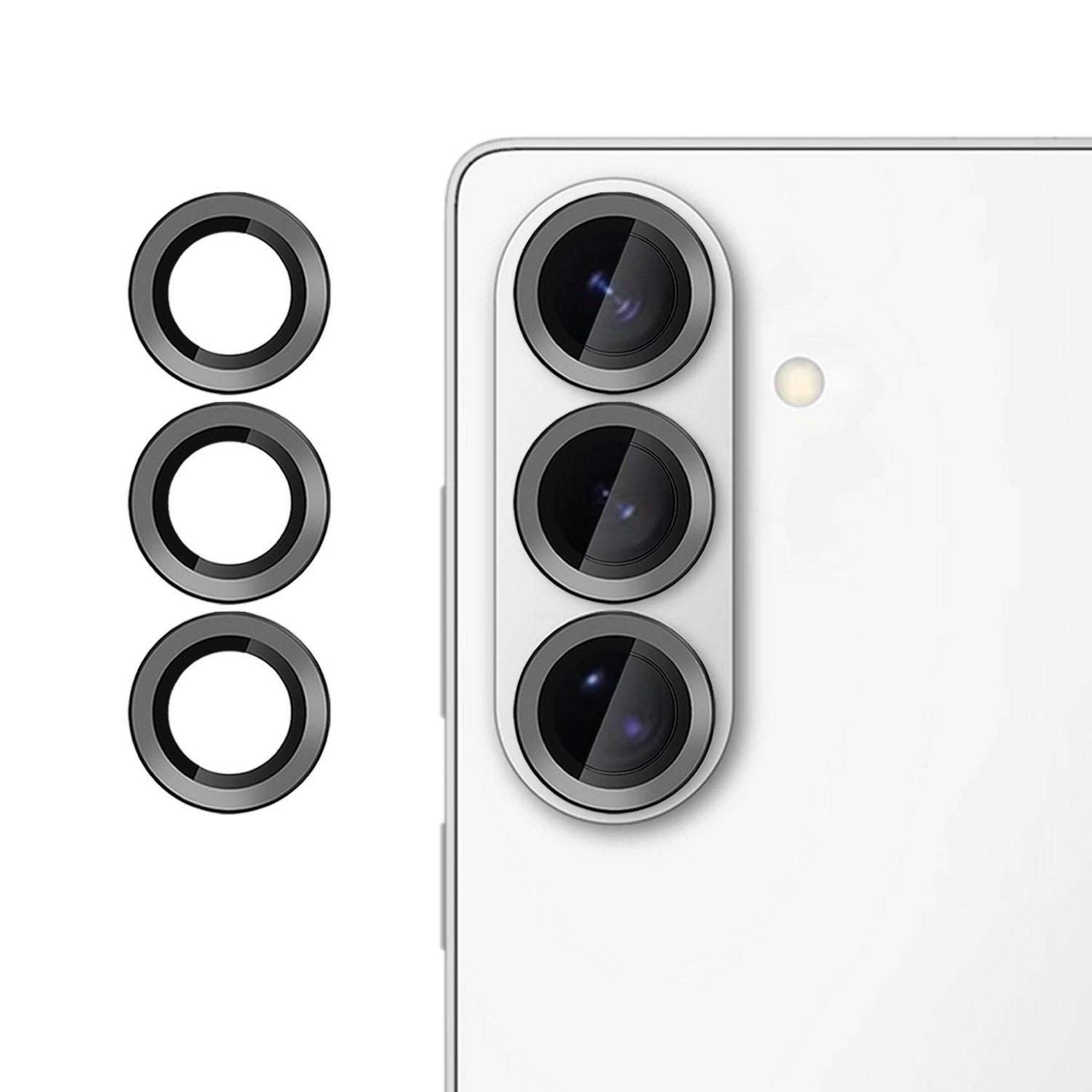 Drei Kameralinsenringe neben dem Triple-Kameramodul auf der Rückseite eines weißen Smartphones, die auf Schutz- oder Ersatzringe für die Handykamera hindeuten.