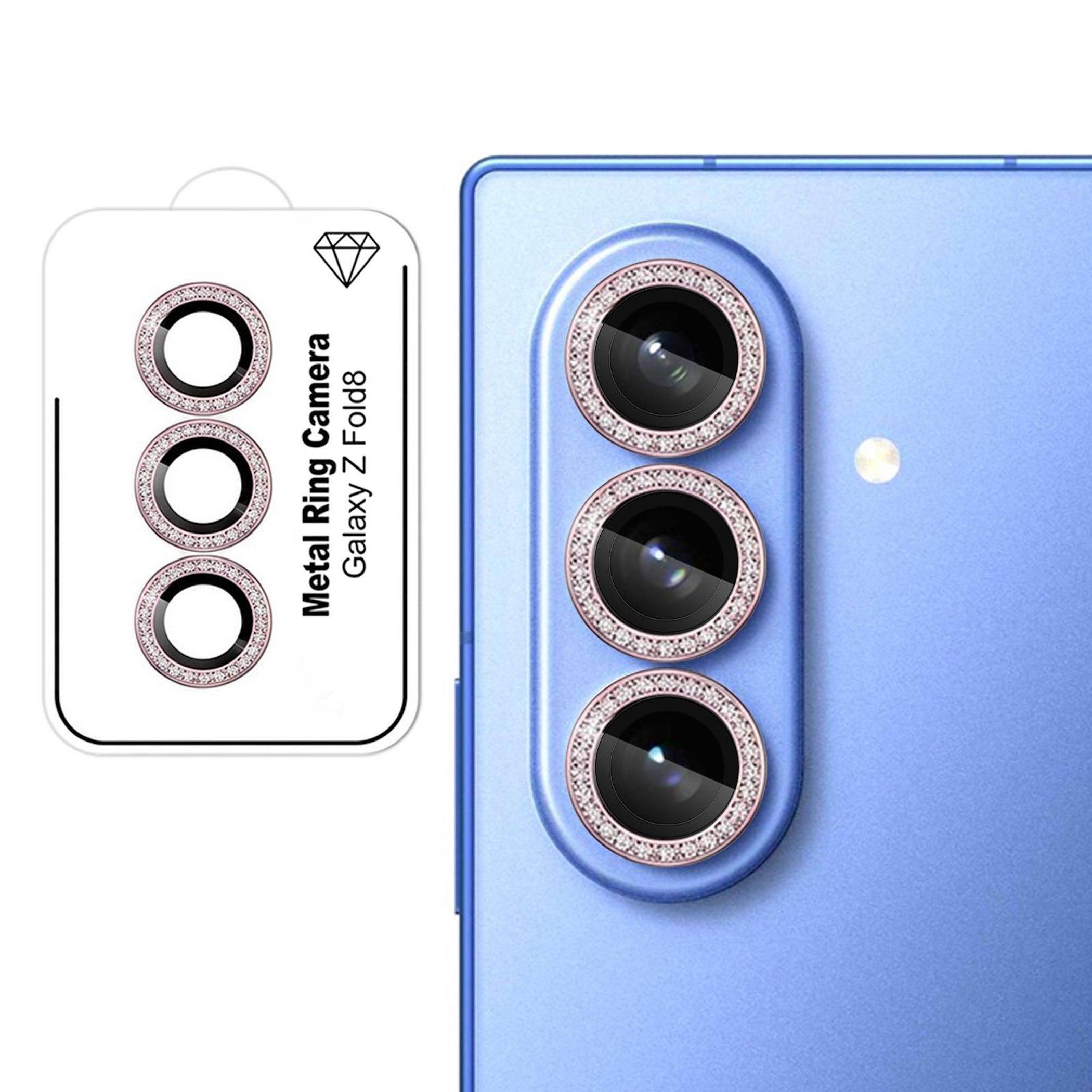 Blaugrünes Galaxy Z Fold8 Telefon, dargestellt mit vertikalem Triple-Kamera-Modul, ausgestattet mit rosa Metallring-Kameraobjektivschutzvorrichtungen; Verpackung daneben dargestellt.
