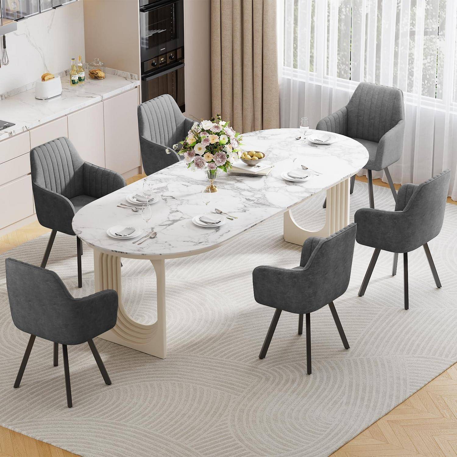 Modernes Esszimmer mit einem ovalem Tisch im Marmor-Look, gedeckt für sechs Personen, dunkelgrauen gepolsterten Stühlen und einem Blumenmittelstück neben einem hellen Fenster.