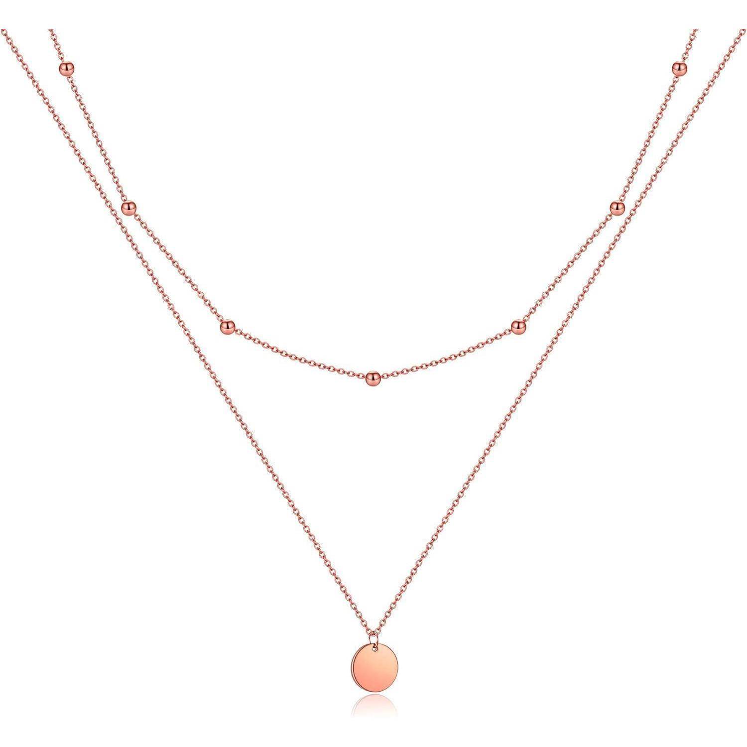 Mehrlagige Roségold-Halskette mit zwei zarten Ketten, eine mit kleinen Perlenakzenten und eine mit einem runden Pfirsich-Anhänger auf weißem Hintergrund.