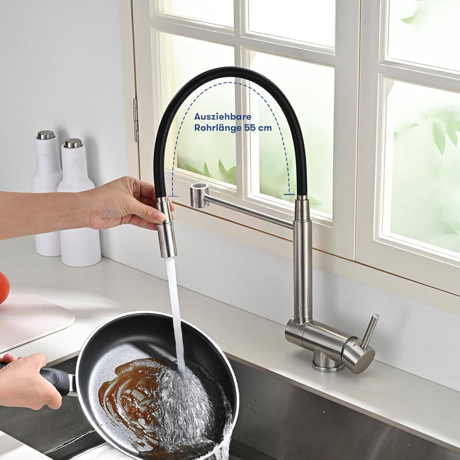 Ausziehbare Küchenarmatur mit schwarzem flexiblem Schlauch, der Wasser in einen Topf in einem hellen Spülbereich dispensiert; der Text besagt „Ausziehbare Rohrlänge 55 cm
