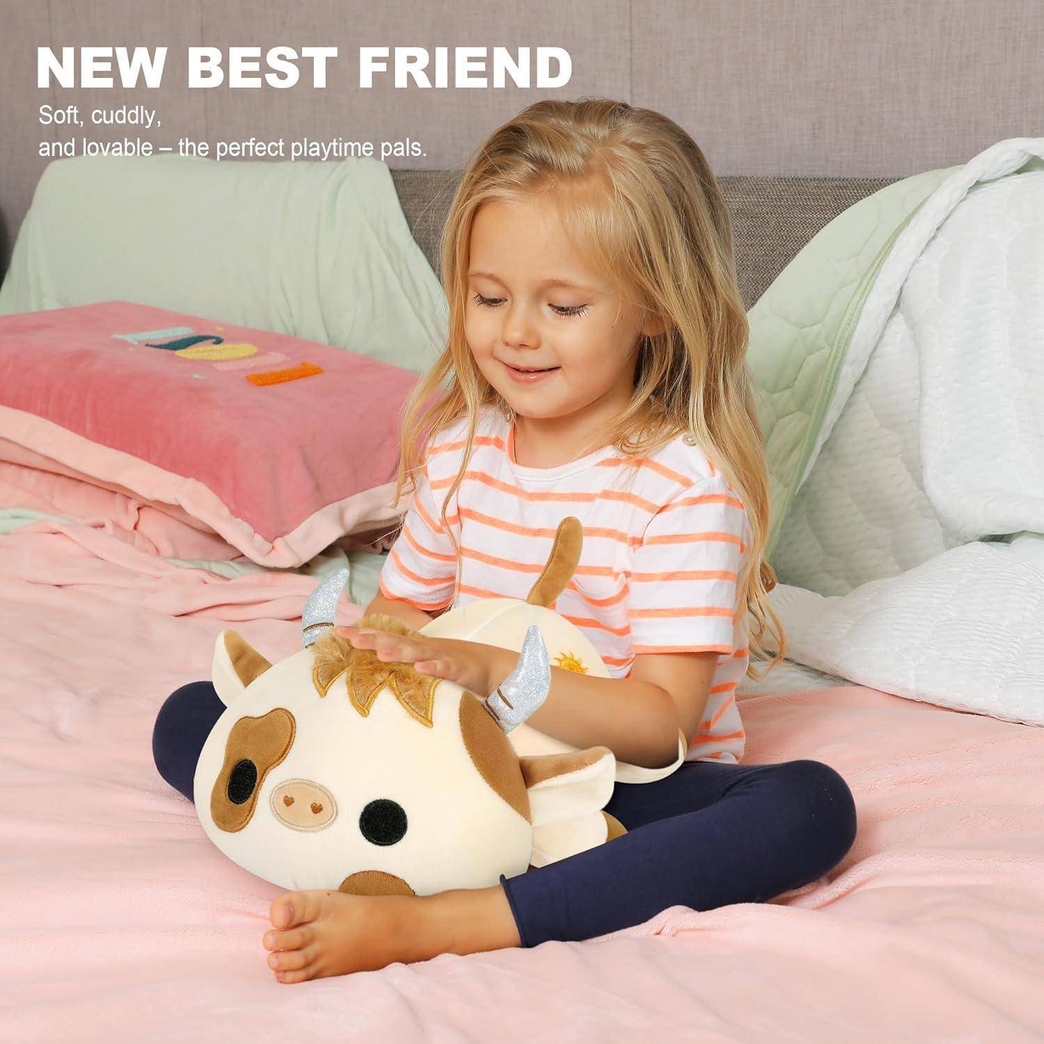 Kleines Mädchen sitzt auf einem Bett und kuschelt ein weiches Kuhplüschtier, mit Text, der lautet „NEUER BESTER FREUND