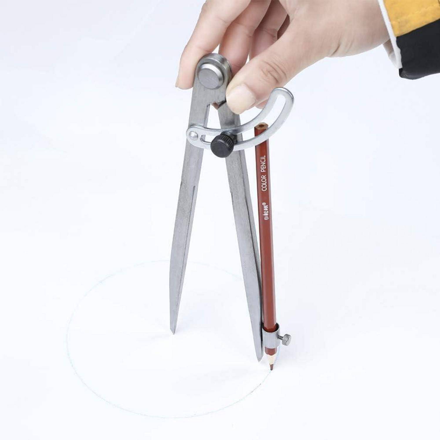 Hand mit einem Metallzirkel beim Zeichnen eines Kreises auf weißem Papier.