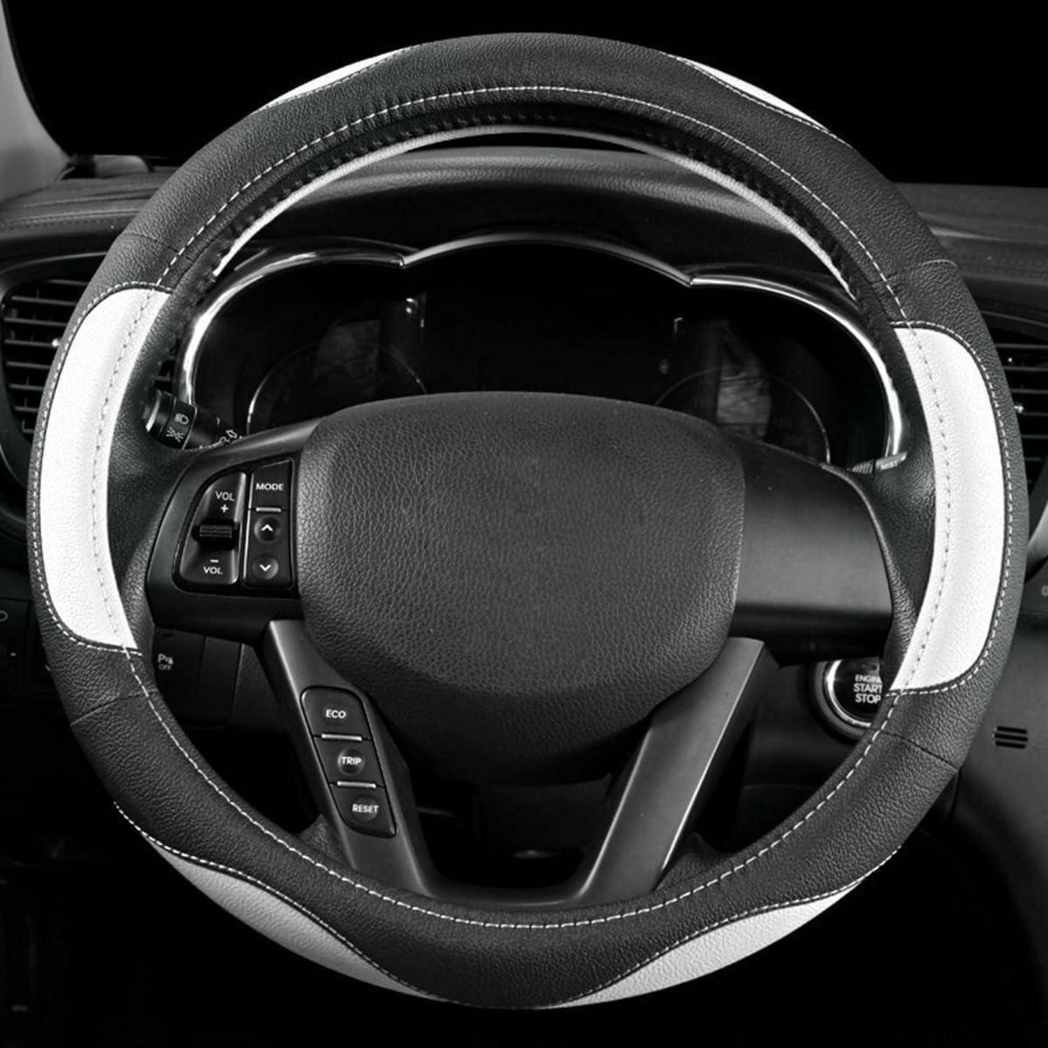 Nahaufnahme eines Autolenkrads mit integrierten Steuertasten, aus der Perspektive des Fahrerplatzes fotografiert.