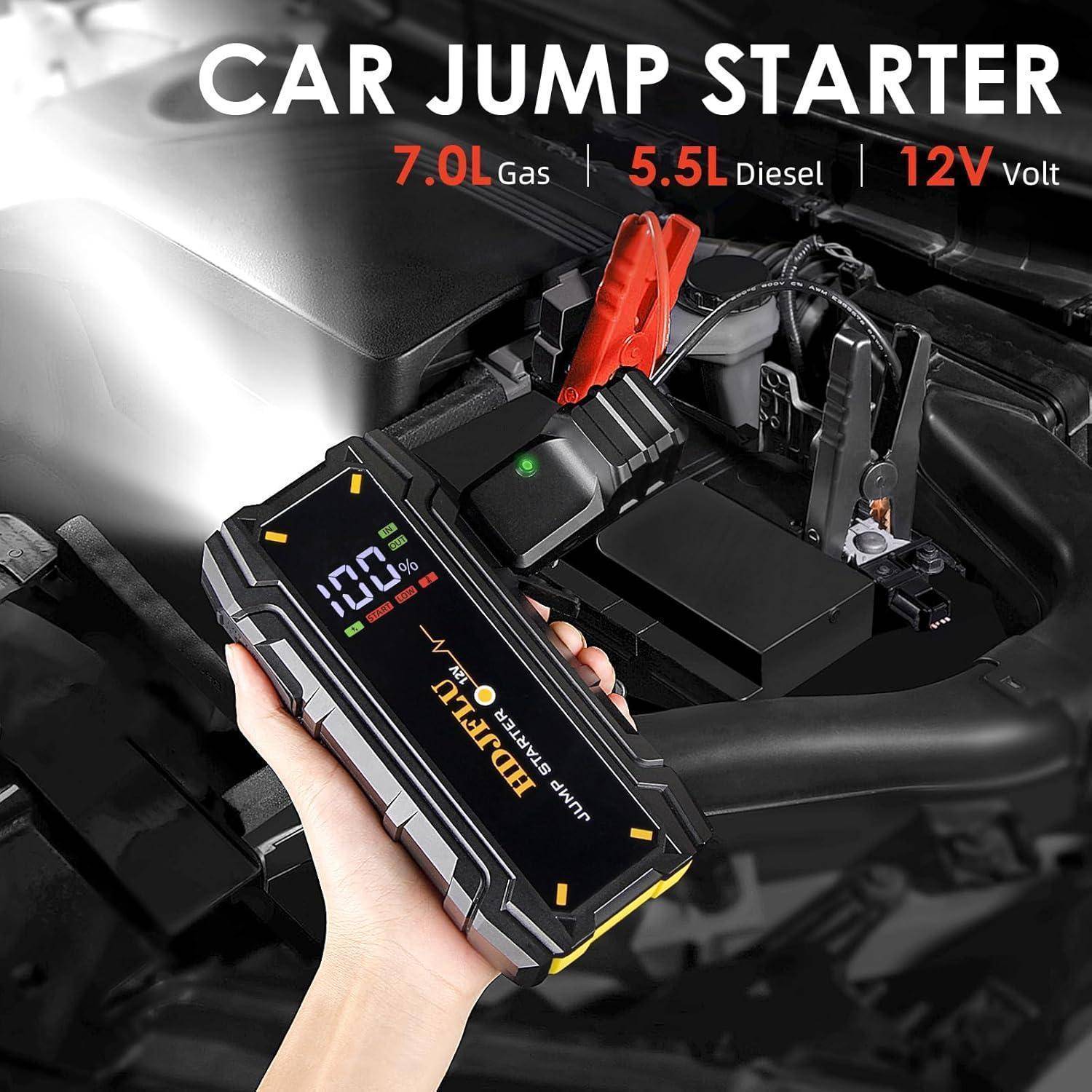 Tragbarer Starthilfe für Autos, angeschlossen an eine Fahrzeugbatterie, mit Display und Klemmen, beschriftet für 7,0L Benzin, 5,5L Diesel, 12V Volt.