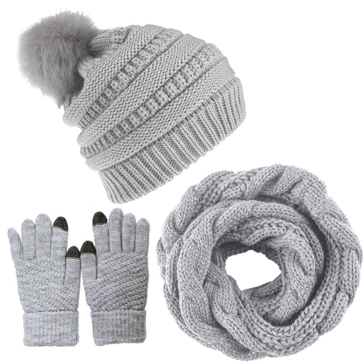 Satz von grauen Winteraccessoires: Strickmütze mit Bommel, passende Handschuhe und ein dicker Schlauchschal auf weißem Hintergrund.