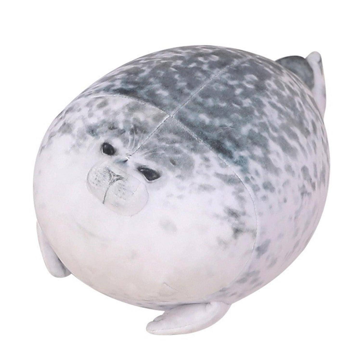 Plüschtier-Robbe mit grauem fleckigem Fell und rundem weißem Gesicht auf einem schlichten weißen Hintergrund.