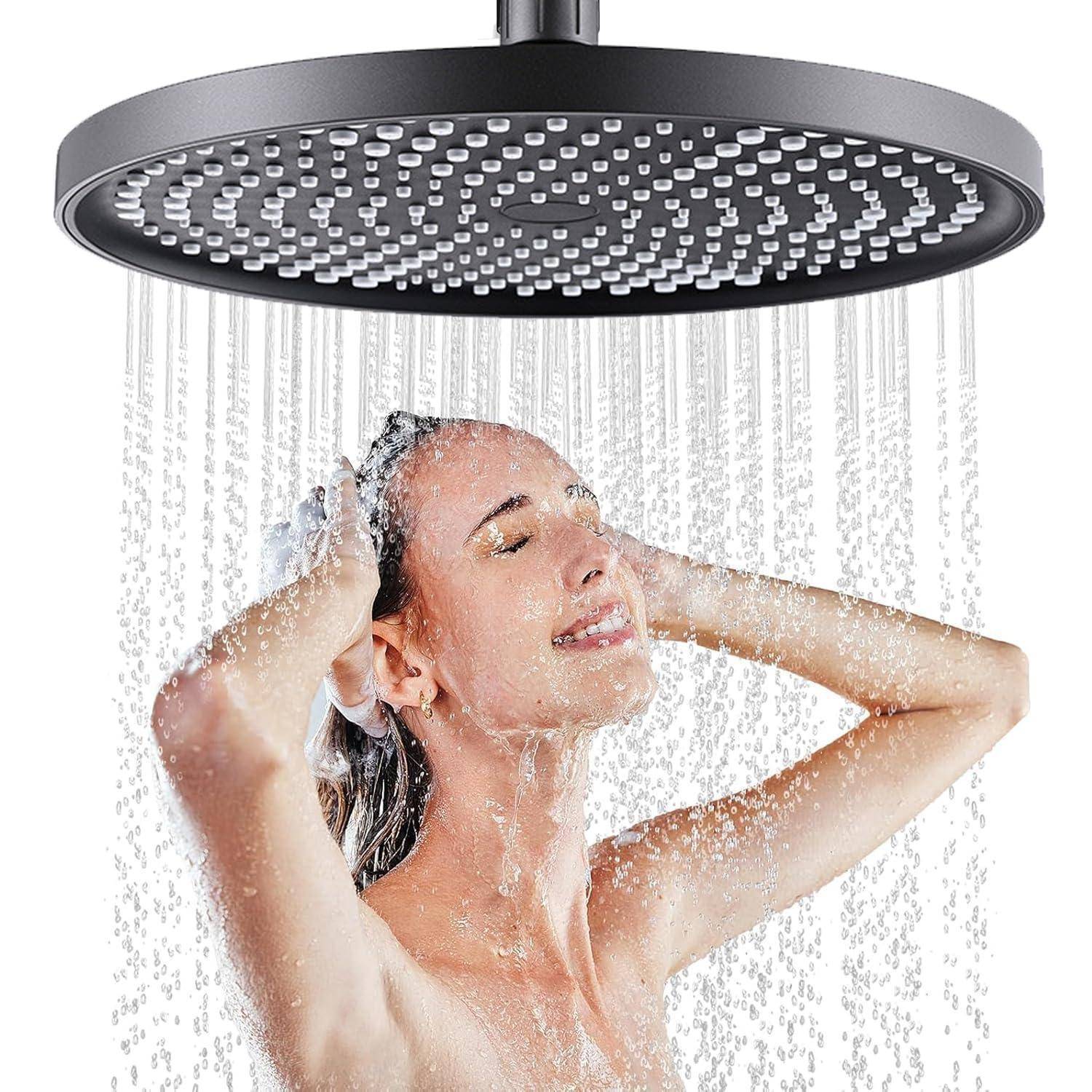 Eine Frau genießt eine Dusche unter einem großen runden Regenduschenkopf mit Wasser, das herabströmt.