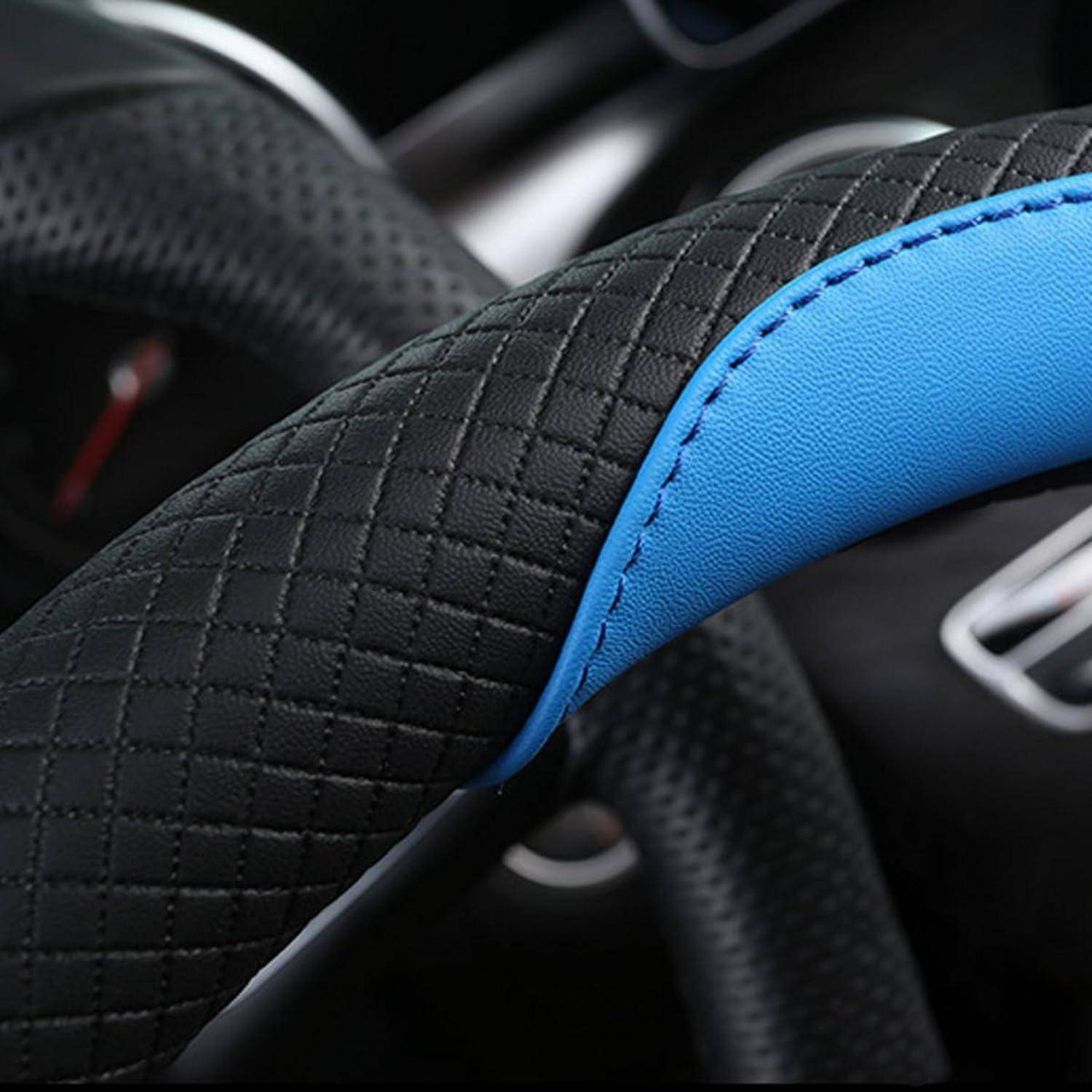Nahaufnahme einer schwarzen strukturierten Lenkradhülle mit einer hell blauen gesteppten Akzentuierung in einem Autoinnenraum.