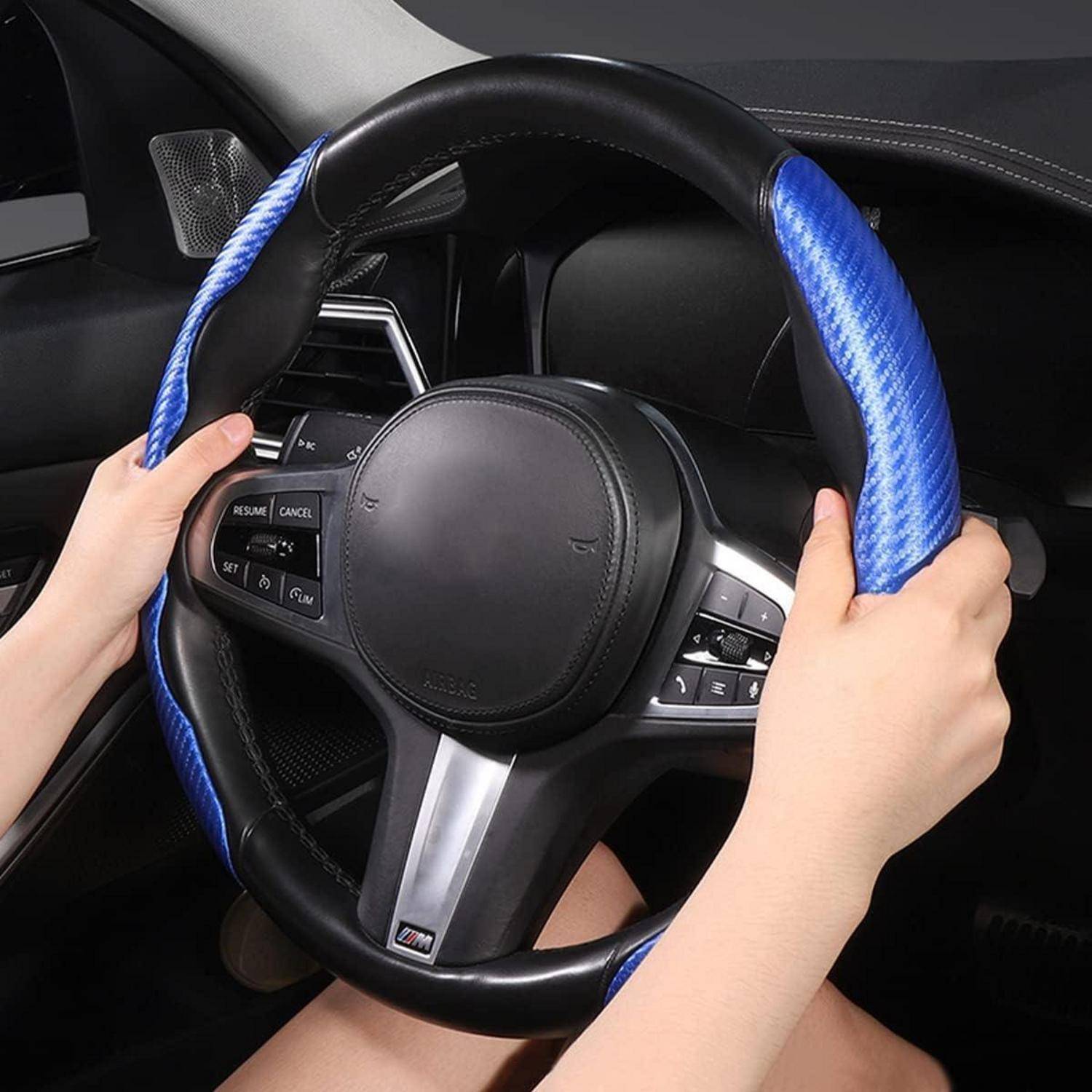 Hände, die ein Lenkrad mit blauem strukturiertem Bezug in einem Fahrzeuginnenraum greifen.