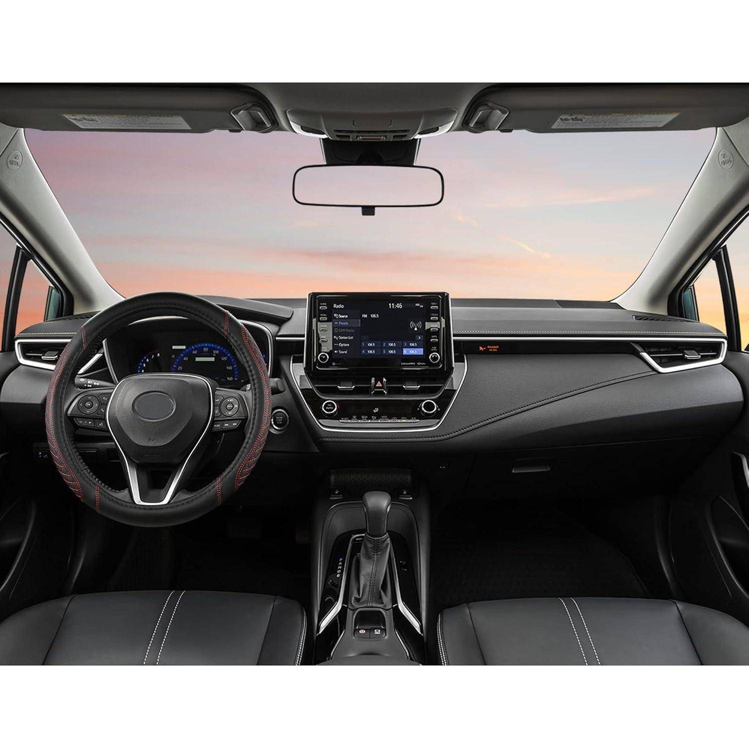 Blick ins Autoinnenraum von den Vordersitzen aus, der das Lenkrad, das digitale Armaturenbrett, den zentralen Touchscreen und den Schalthebel bei Sonnenuntergang zeigt.