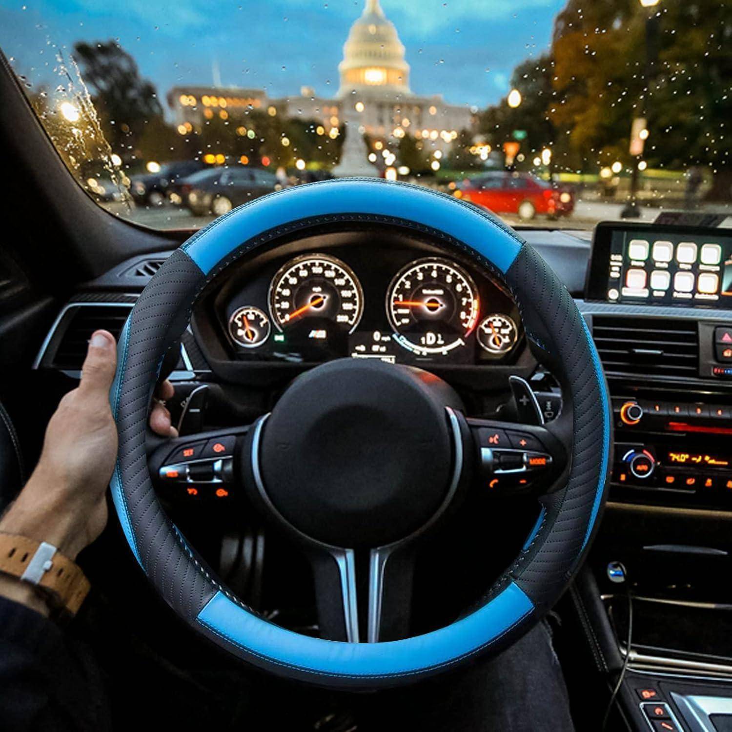 Blick des Fahrers auf das Innere eines Autos mit Händen auf einem blau-schwarzen Lenkrad, leuchtenden Armaturenbrettanzeigen und einem Stadtgebäude, das bei Dämmerung durch die Windschutzscheibe sichtbar ist.
