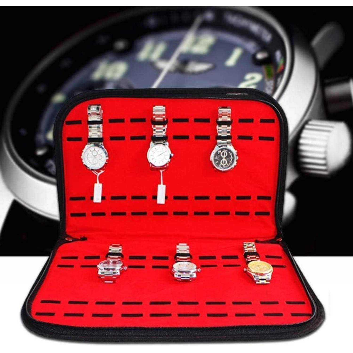 Offene Uhrenbox mit sechs Armbanduhren auf roten gepolsterten Fächern ausgestellt, mit einer unscharfen großen Uhr im Hintergrund.
