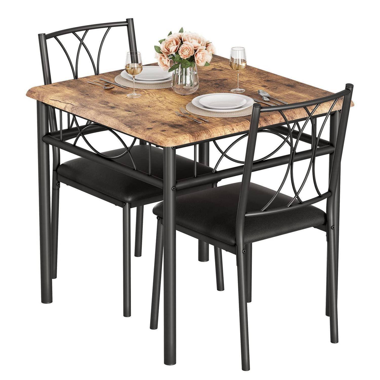 Kleines Esszimmerset mit holzoptischem quadratischem Tisch, zwei schwarzen Metallstühlen und Gedeck mit Blumenmittelstück auf weißem Hintergrund