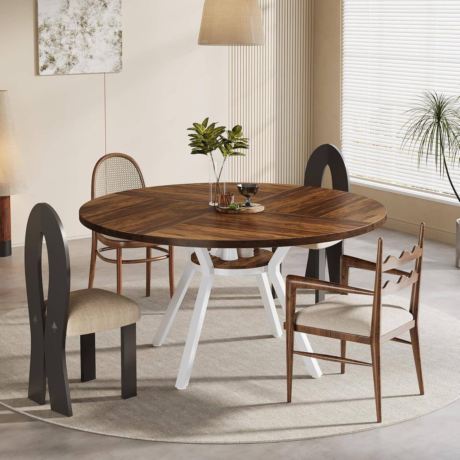 Runder Holzesstisch mit gemischten modernen Stühlen in einem hellen, minimalistischen Esszimmer, mit einer kleinen Pflanze als Tischdekoration und großen Fensterrollos.