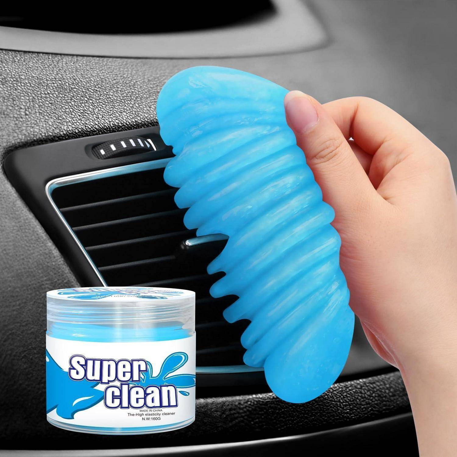 Hand drückt ein blaues Gel-Reinigungspad gegen eine Autolüftung, mit einem 