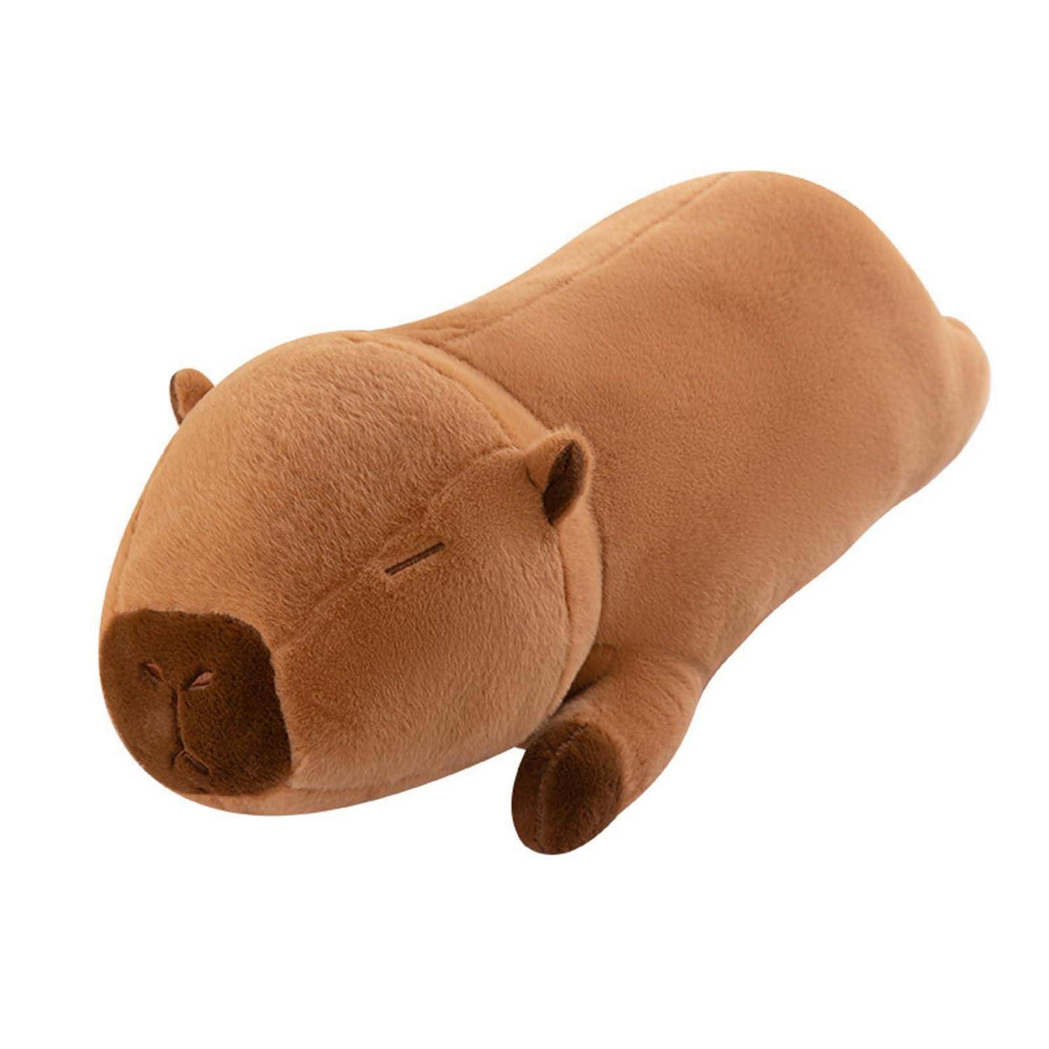 Braunes Plüsch-Capybara-Spielzeug auf weißem Hintergrund liegend, von der Seite gezeigt.