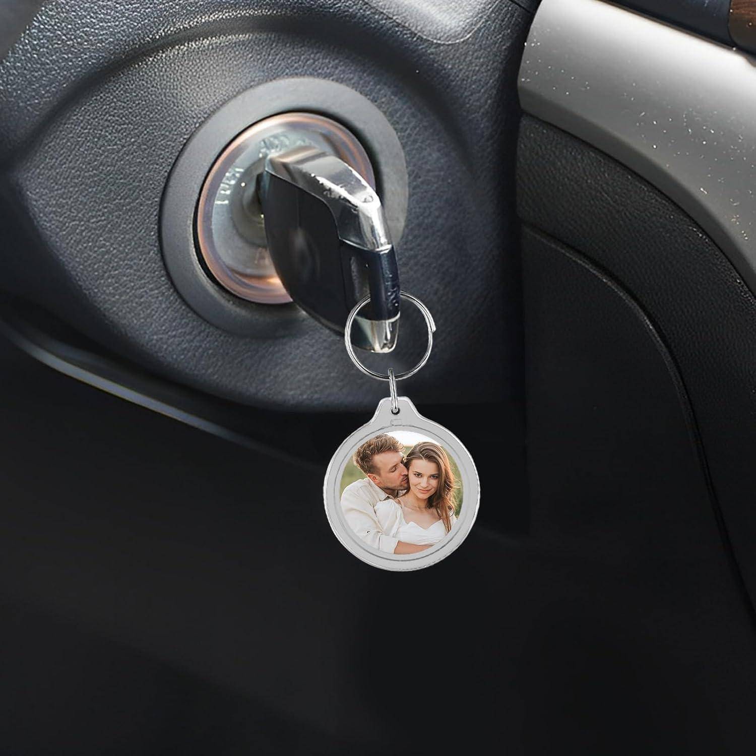Autoschlüssel in der Zündung mit einem baumelnden Fotoschlüsselanhänger daran befestigt.