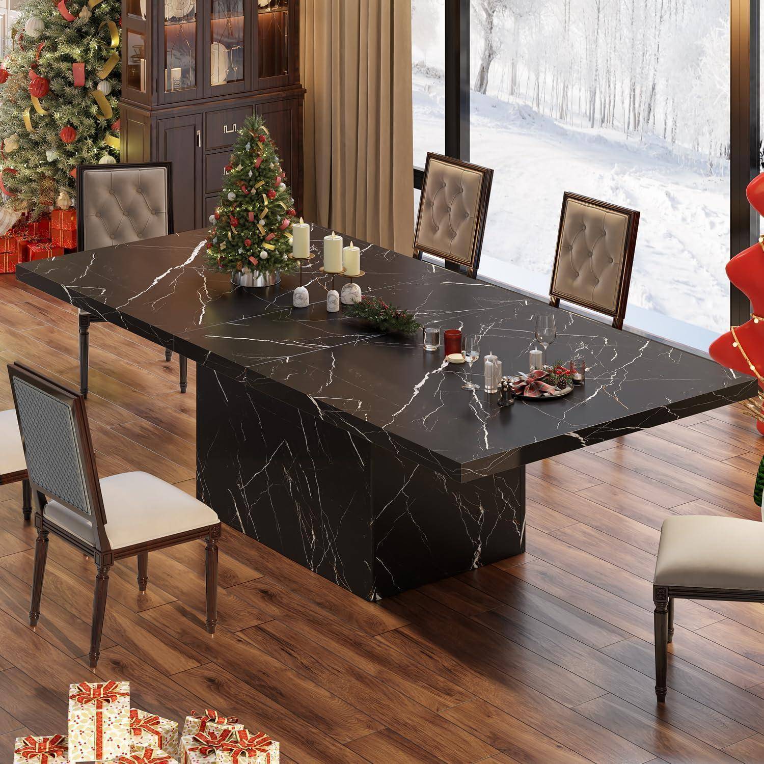 Ein modernes Esszimmer mit einem schwarzen Marmortisch, gepolsterten Stühlen, Weihnachtsdekoration und einem verschneiten Waldblick durch große Fenster.