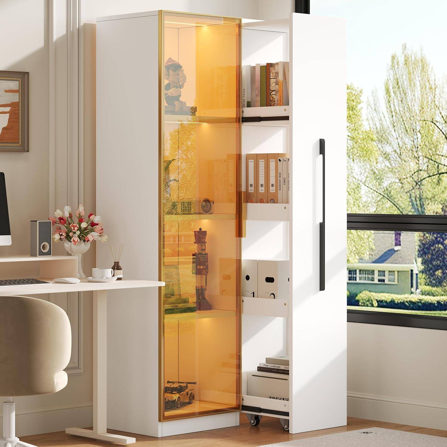 Hoher weißer Schrank mit einer offenen, bernsteingetönten Glastür, Regale mit Dateien und Dekoration im Inneren, in einem hellen Homeoffice neben einem Schreibtisch und Fenster.