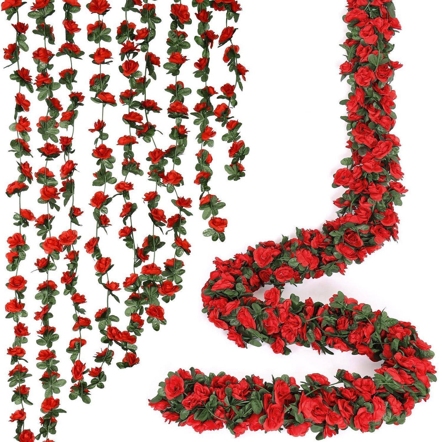 Rote Rosengirlanden und hängende Blumenstränge, die in verschlungenen Buchstabenformen auf weißem Hintergrund angeordnet sind.