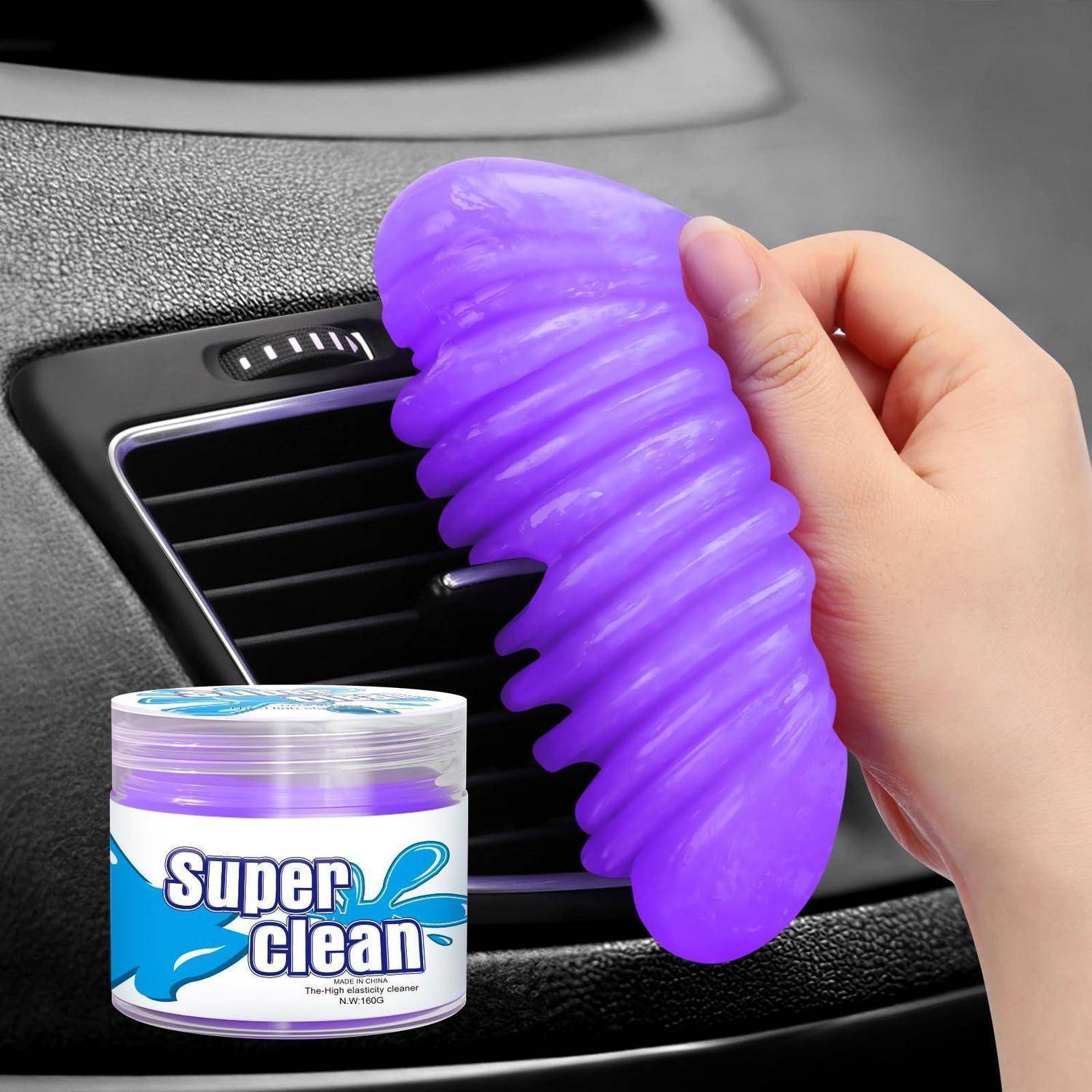 Hand hält einen violetten Gel-Reiniger gegen einen Autolüftungsschlitz, mit einem „Super clean