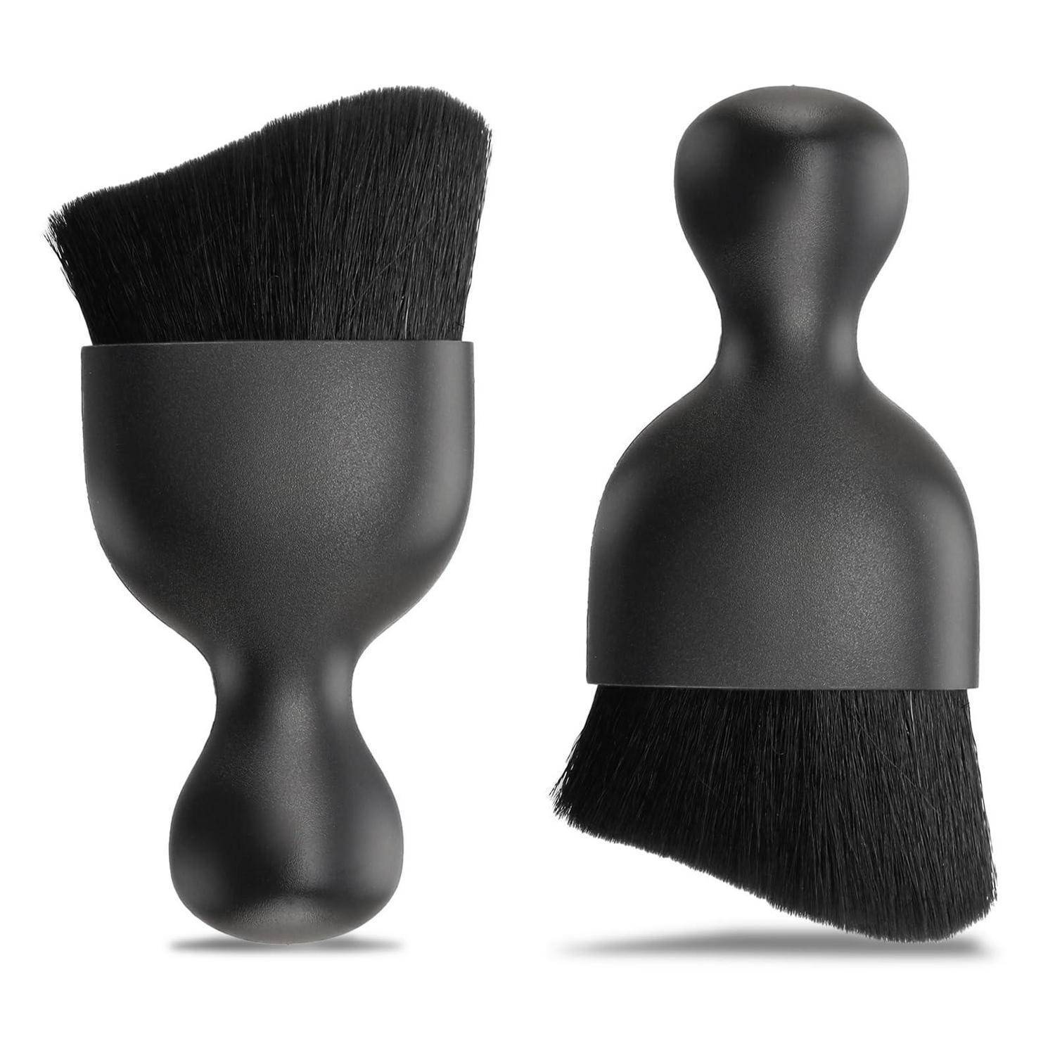 Zwei schwarze Makeup-Pinsel mit abgerundeten ergonomischen Griffen, die nebeneinander auf weißem Hintergrund gezeigt werden, einer aufrecht und einer umgekehrt.