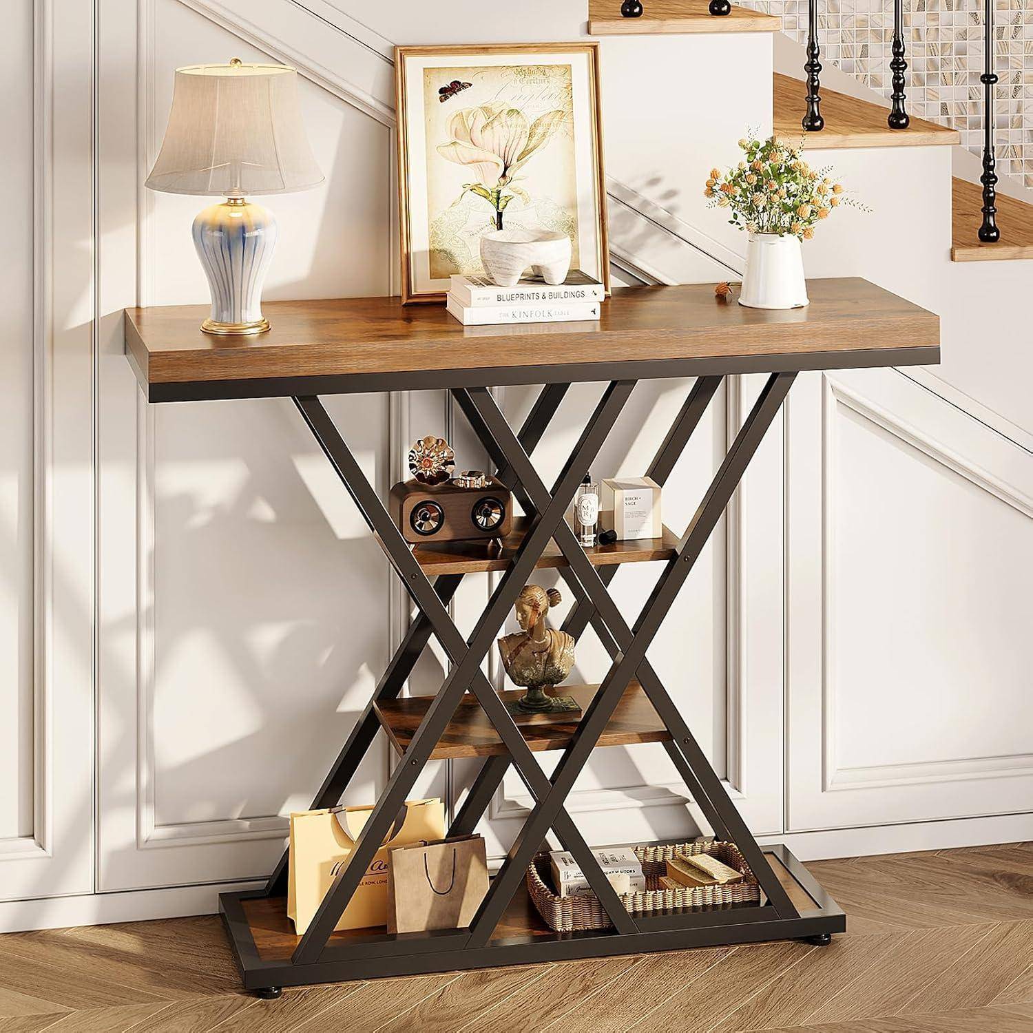 Konsolentisch mit Metallsockel in Kreuzform, Holzplatte, Lampe, Bilderrahmen, Blumen und kleine Dekorationsgegenstände in einem Treppenflur-Eingangsbereich
